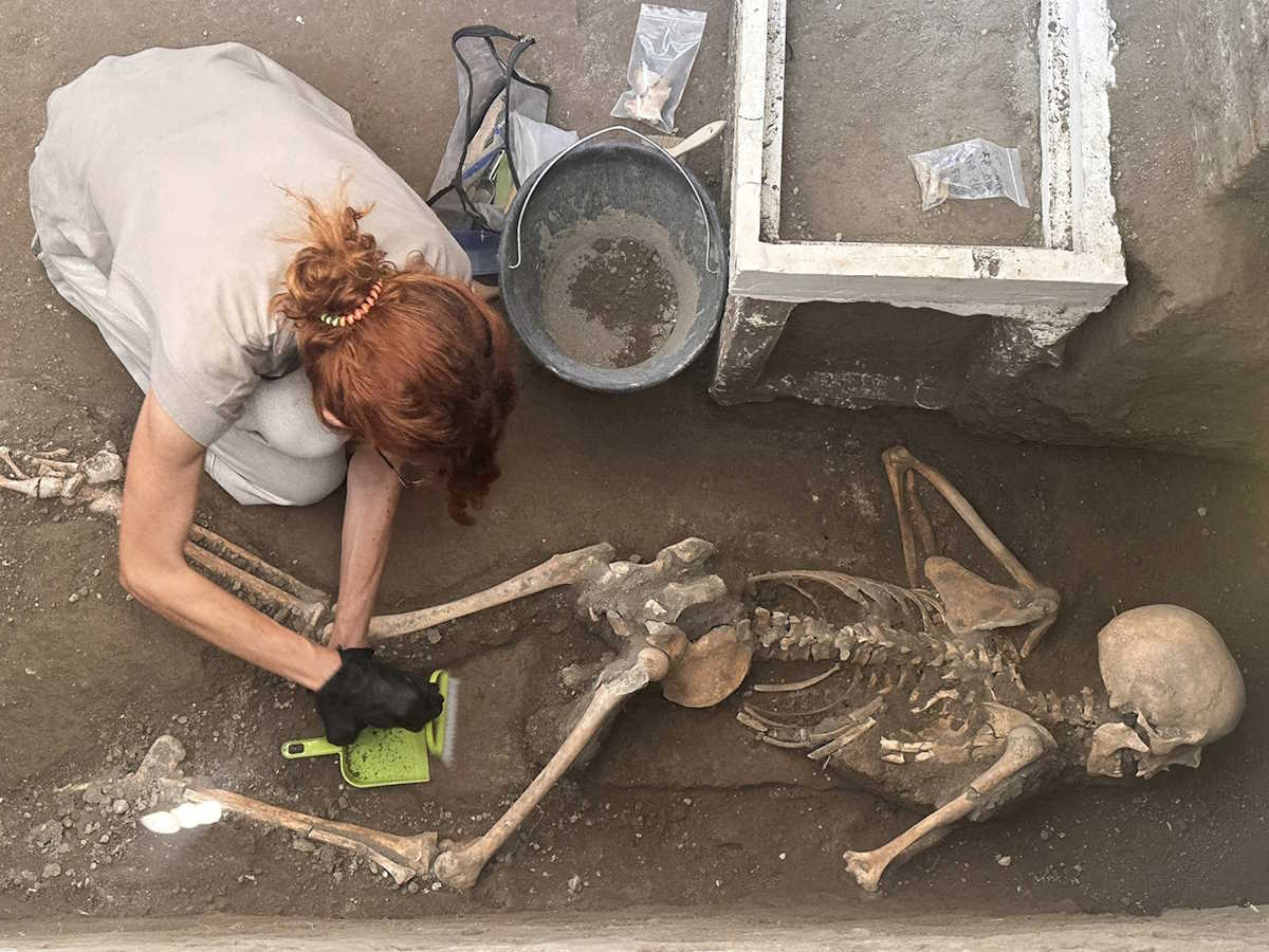 An archaeologist works on the recently discovered remains of a victim in the archaeological site of the ancient city of Pompeii, which was destroyed in AD 79 by the eruption of Mount Vesuvius, in Pompeii Italy, July 5, 2024. Parco Acheologico di Pompei
