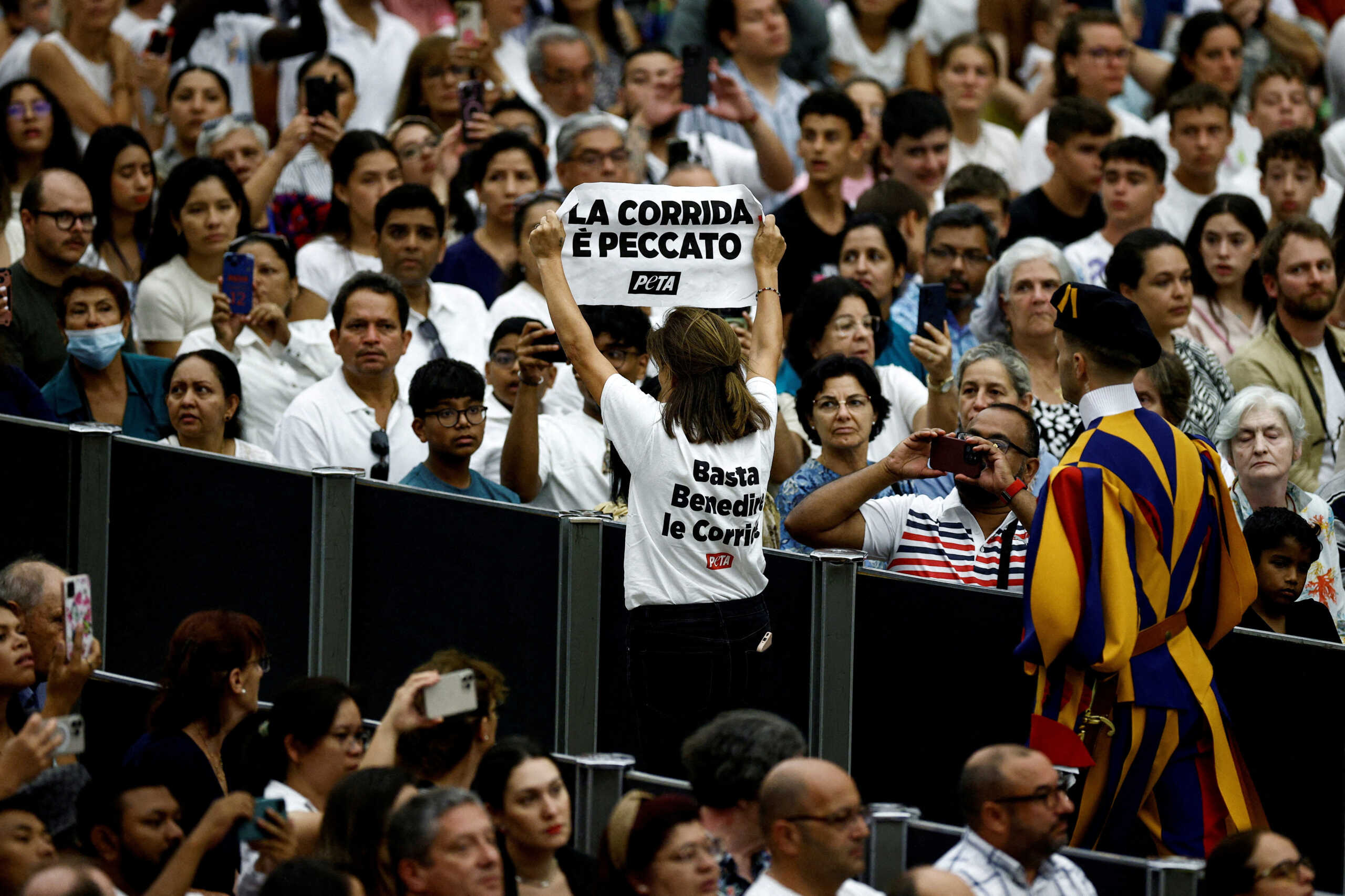 FILE PHOTO: A PETA activist holds a banner reading in Italian: "Bullfight is sin", during the weekly general audience in Paul VI hall at the Vatican, August 7, 2024. REUTERS