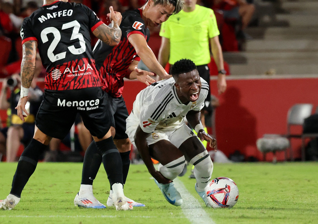 Soccer Football - LaLiga - RCD Mallorca vs Real Madrid - Mallorca Son Moix Stadium, Palma de Mallorca, Spain - August 18, 2024 Real Madrid's Vinicius Junior in action with RCD Mallorca's Takuma Asano and Pablo Maffeo REUTERS