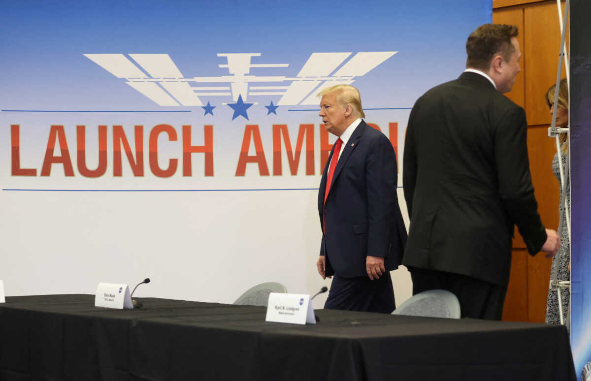 FILE PHOTO: U.S. President Donald Trump passes SpaceX founder and CEO Elon Musk as he arrives with first lady Melania Trump to attend a SpaceX mission briefing before watching the planned launch of a SpaceX Falcon 9 rocket carrying two NASA astronauts to the International Space Station at the Kennedy Space Center in Cape Canaveral, Florida, U.S., May 27, 2020. REUTERS