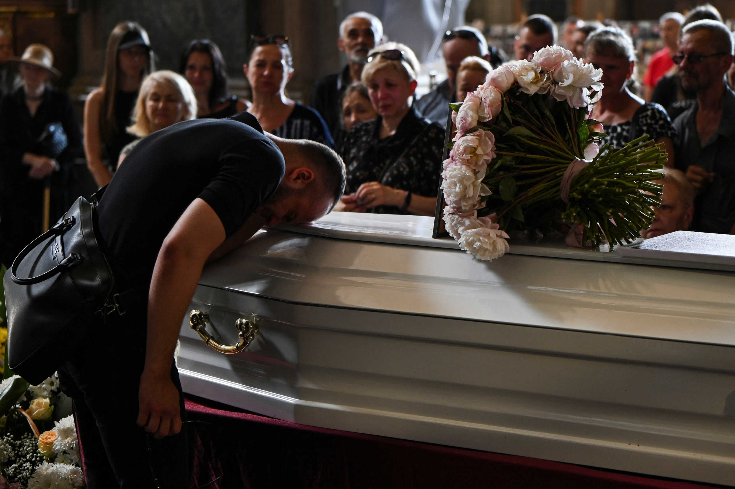 A man reacts over a coffin with the body of the doctor nephrologist Svitlana Lukianchuk, a 30-year-old, who was killed by a Russian missile strike at Kyiv's Ohmatdyt Children's Hospital, amid Russia's attack on Ukraine, during a funeral service in Lviv, Ukraine July 10, 2024. REUTERS