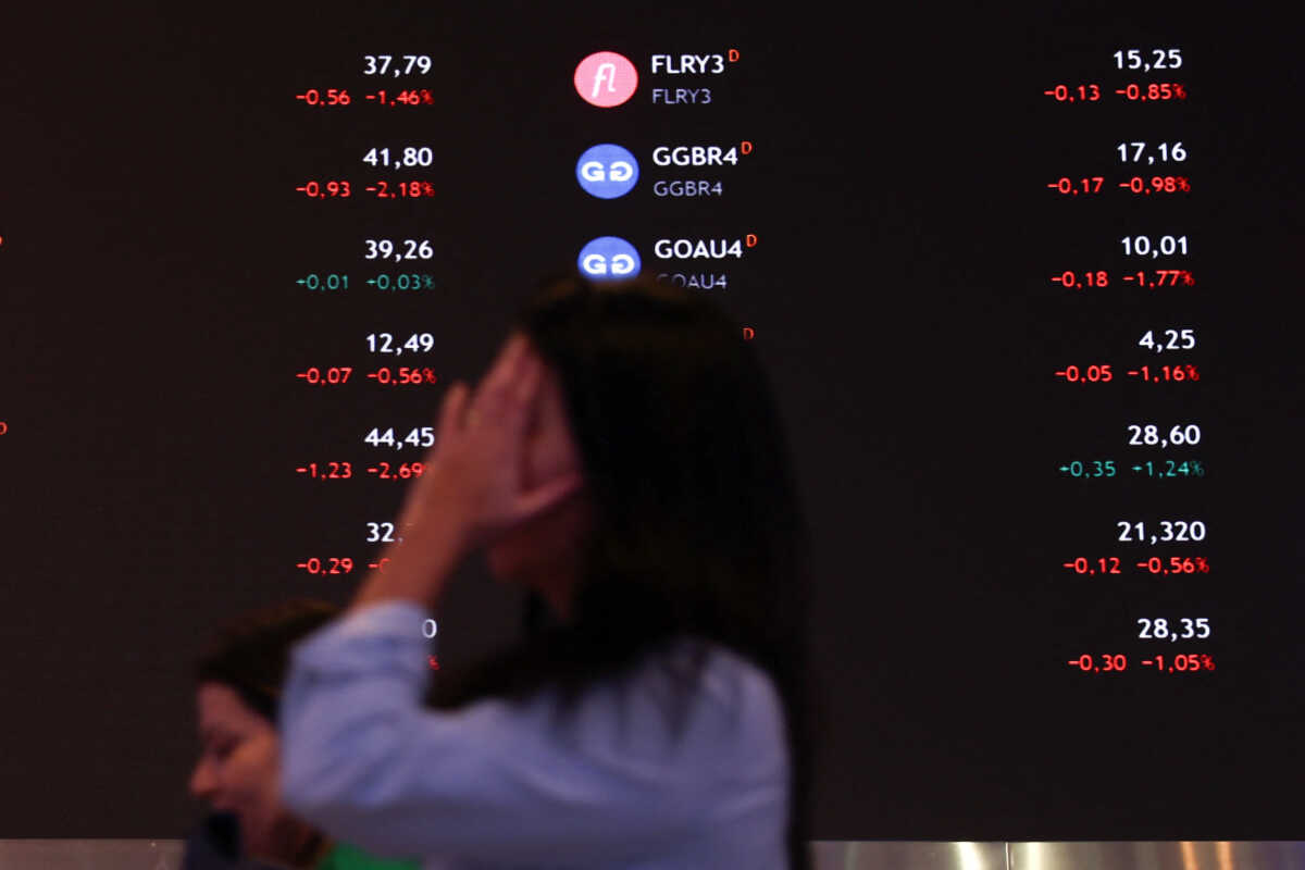 A person walks by an electronic board displaying information of recent fluctuations of market indices at the B3 Stock Exchange in Sao Paulo, Brazil August 5, 2024. REUTERS