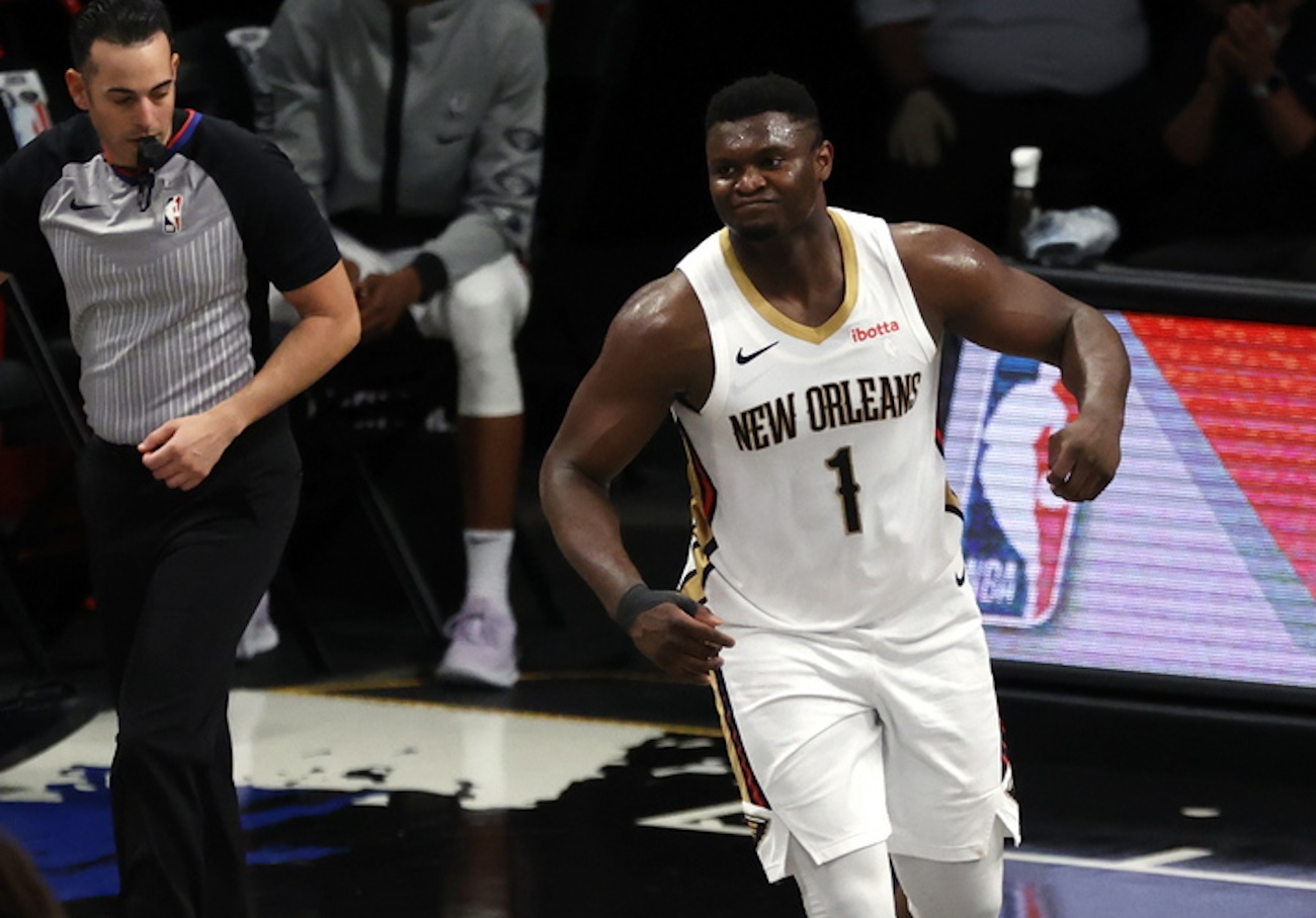epa09121606 New Orleans Pelicans forward Zion Williamson (R) reacts as he tries to put his sneaker back on after losing his shoe as he tries to recover the ball in the first half of the NBA basketball game between the New Orleans Pelicans and the Brooklyn Nets at the Barclays Center in Brooklyn, New York, USA, 07 April 2021.  EPA