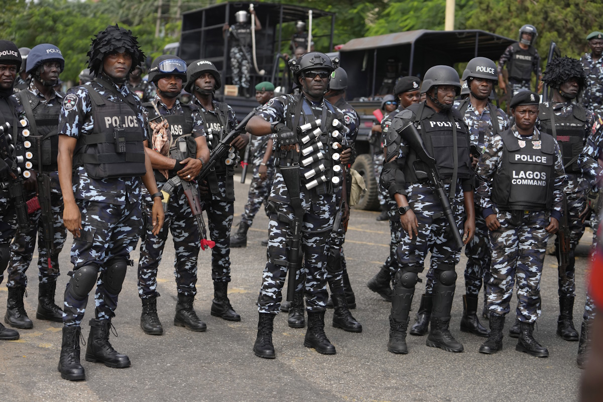 Nigeria police officers stand guard during a candle light procession in honour of all protesters killed nationwide at the recently economic hardship protest, in Lagos, Nigeria, Friday, Aug. 9, 2024. (AP Photo