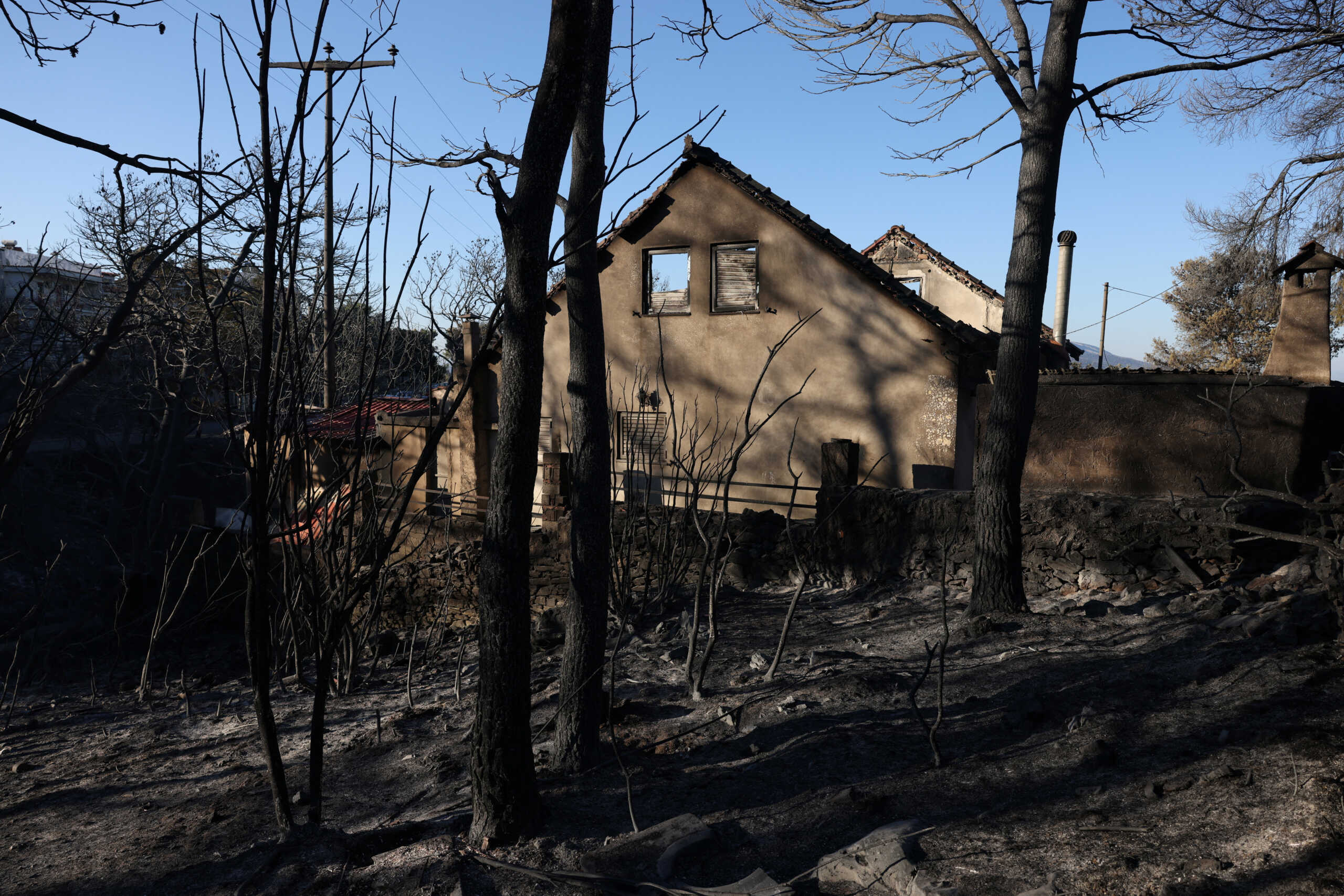 Burned houses are seen following a wildfire in the Penteli area near Athens, Greece, August 13, 2024. REUTERS