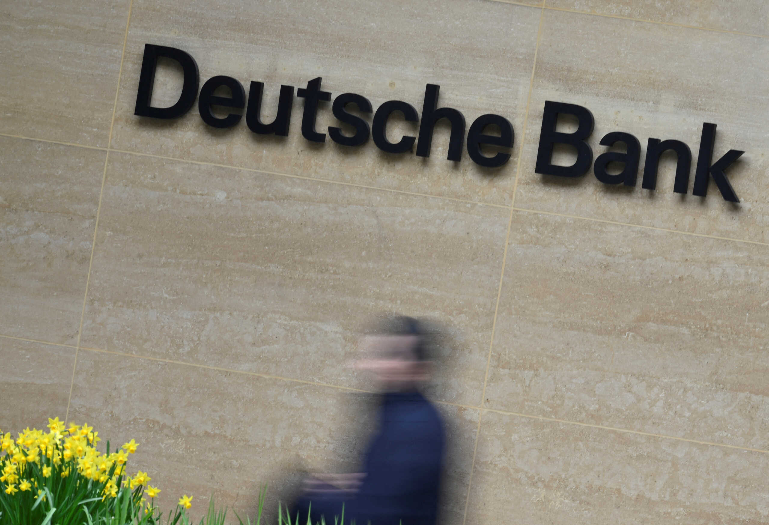 FILE PHOTO: A worker walks past Deutsche Bank offices in London, Britain, March 16, 2023. REUTERS