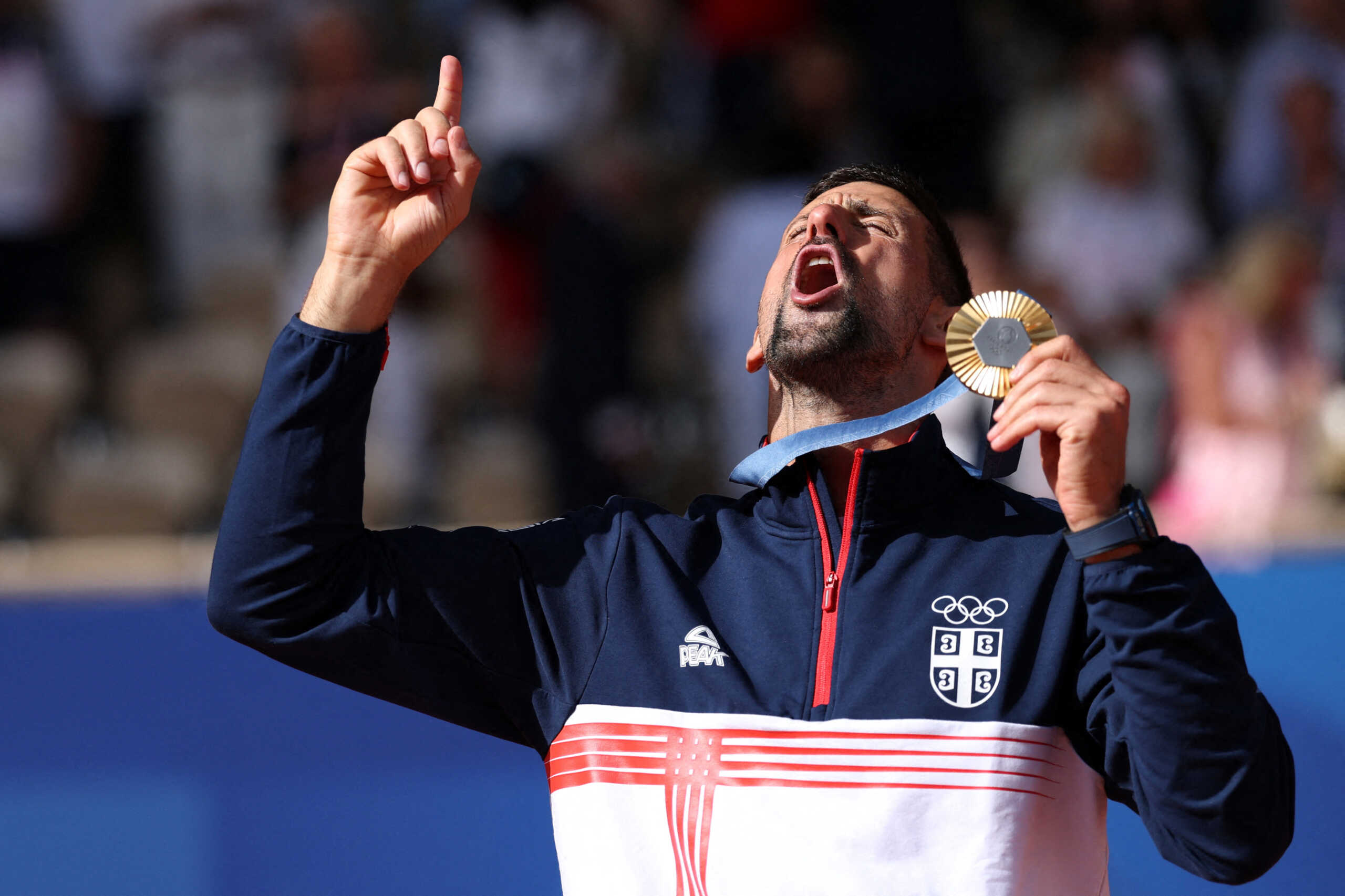 Paris 2024 Olympics - Tennis - Men's Singles Victory Ceremony - Roland-Garros Stadium, Paris, France - August 04, 2024. Gold medallist Novak Djokovic of Serbia gestures while holding his medal. REUTERS