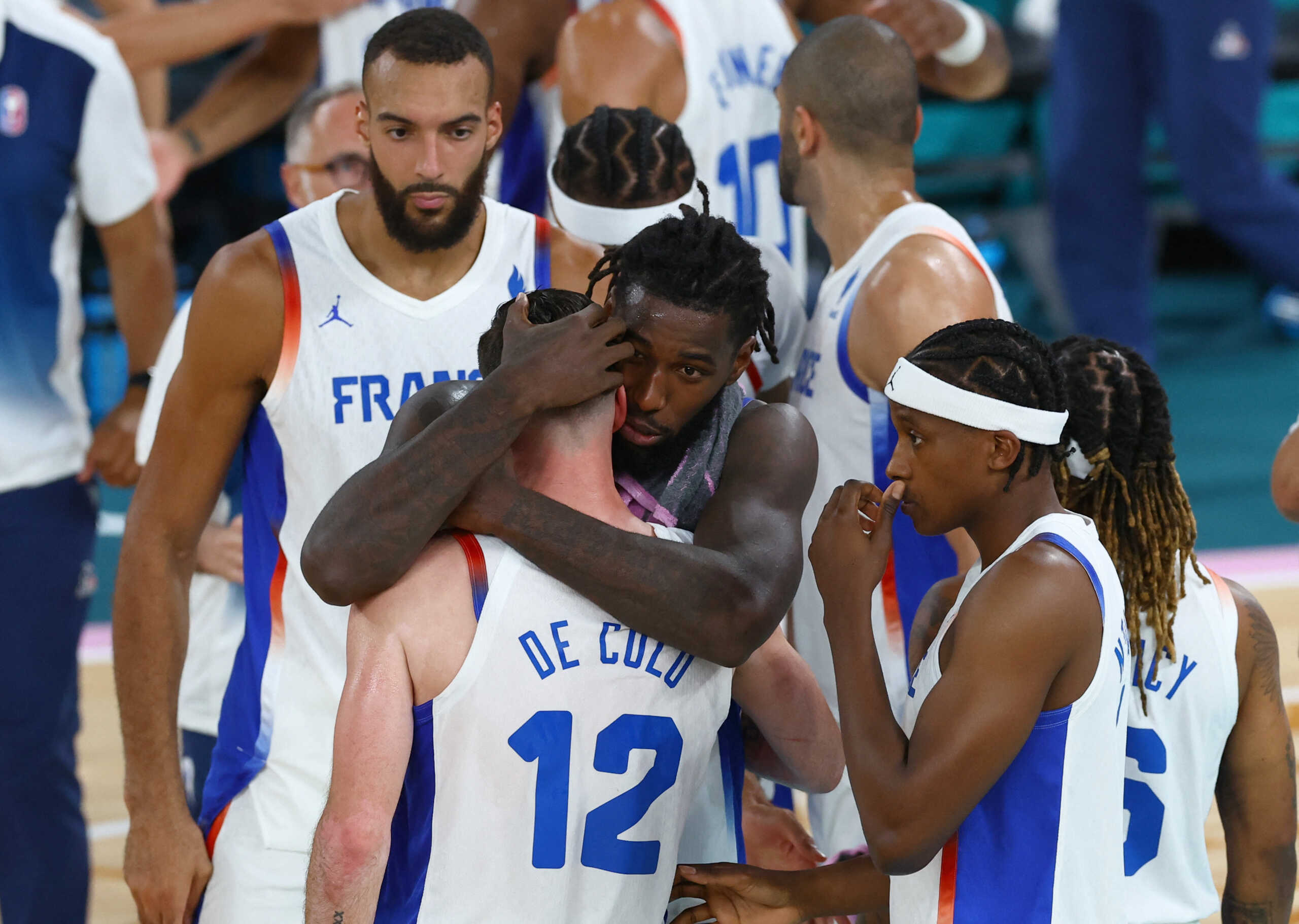 Paris 2024 Olympics - Basketball - Men's Gold Medal Game - France vs United States - Bercy Arena, Paris, France - August 10, 2024. Mathias Lessort of France hugs Nando de Colo of France after United States win gold. REUTERS