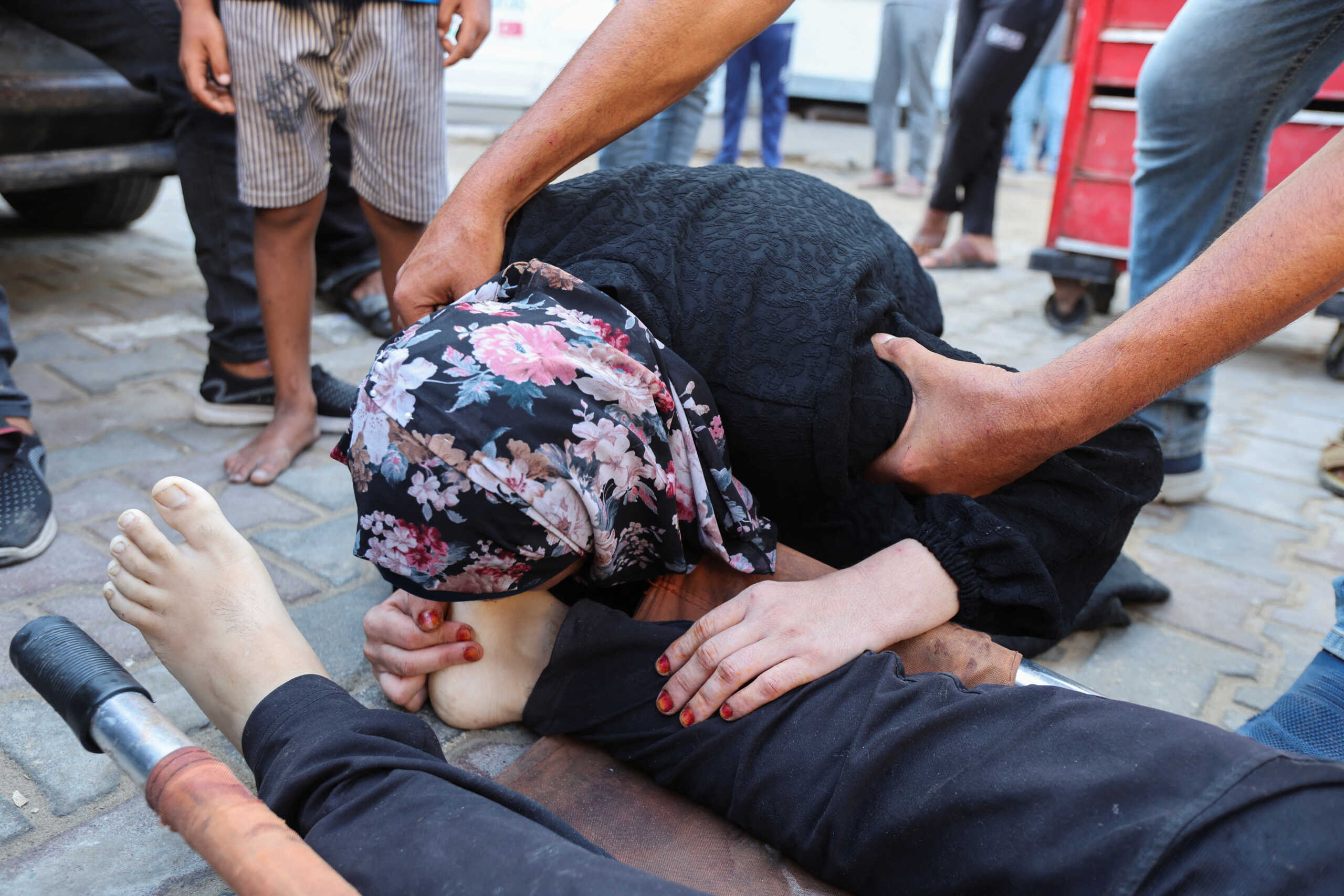 SENSITIVE MATERIAL. THIS IMAGE MAY OFFEND OR DISTURB    A mourner reacts next to the body of Palestinian Ismail Nofal, who was killed in an Israeli strike on a tent camp for displaced people, amid the Israel-Hamas conflict, at Al Aqsa Martyrs hospital in Deir Al-Balah in the central Gaza Strip, August 4, 2024. REUTERS