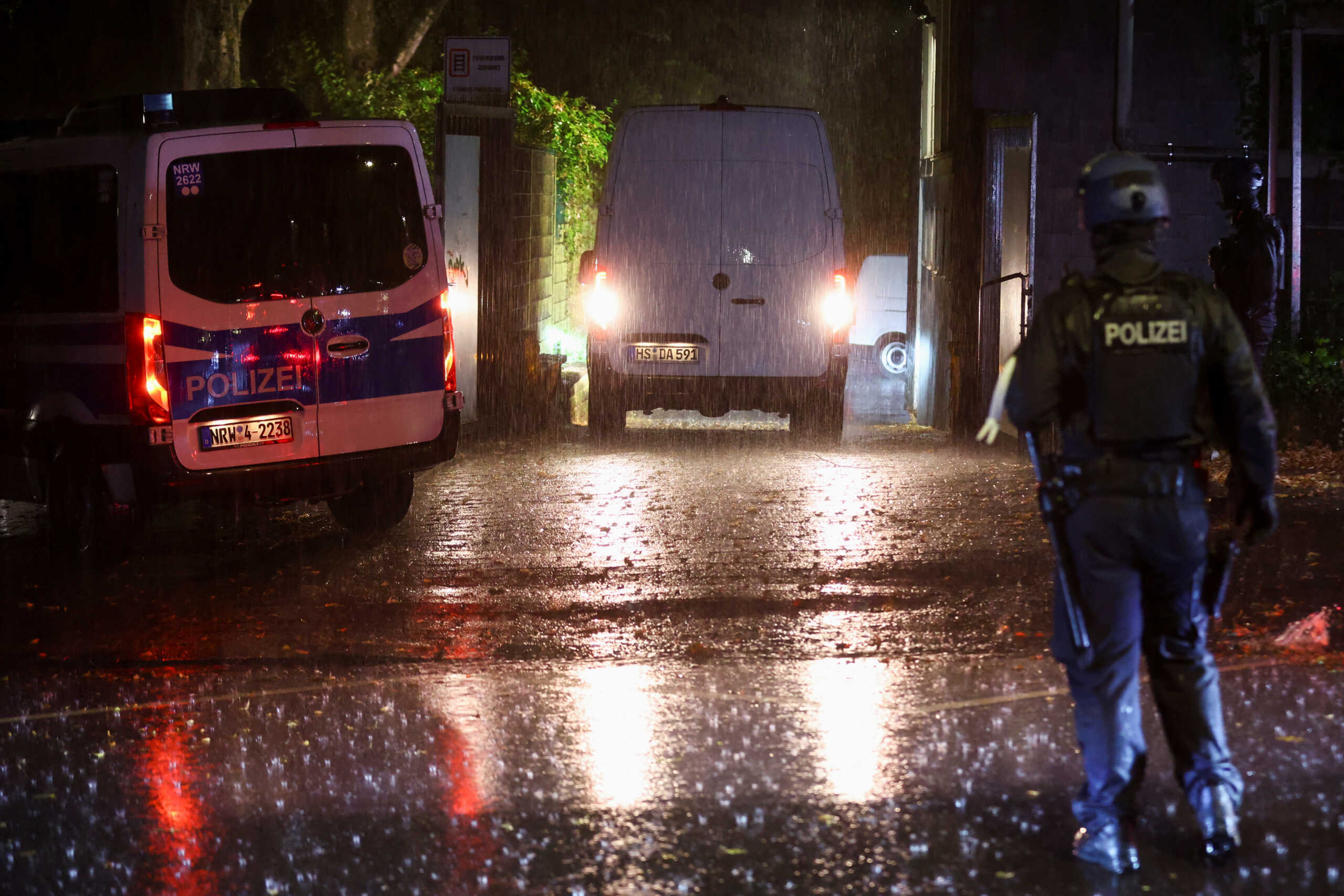 Police officers stand, as a vehicle leaves, after a person was detained, following an incident in which several individuals were killed after a man randomly stabbed passers-by with a knife at a city festival, in Solingen, Germany, August 24, 2024. REUTERS