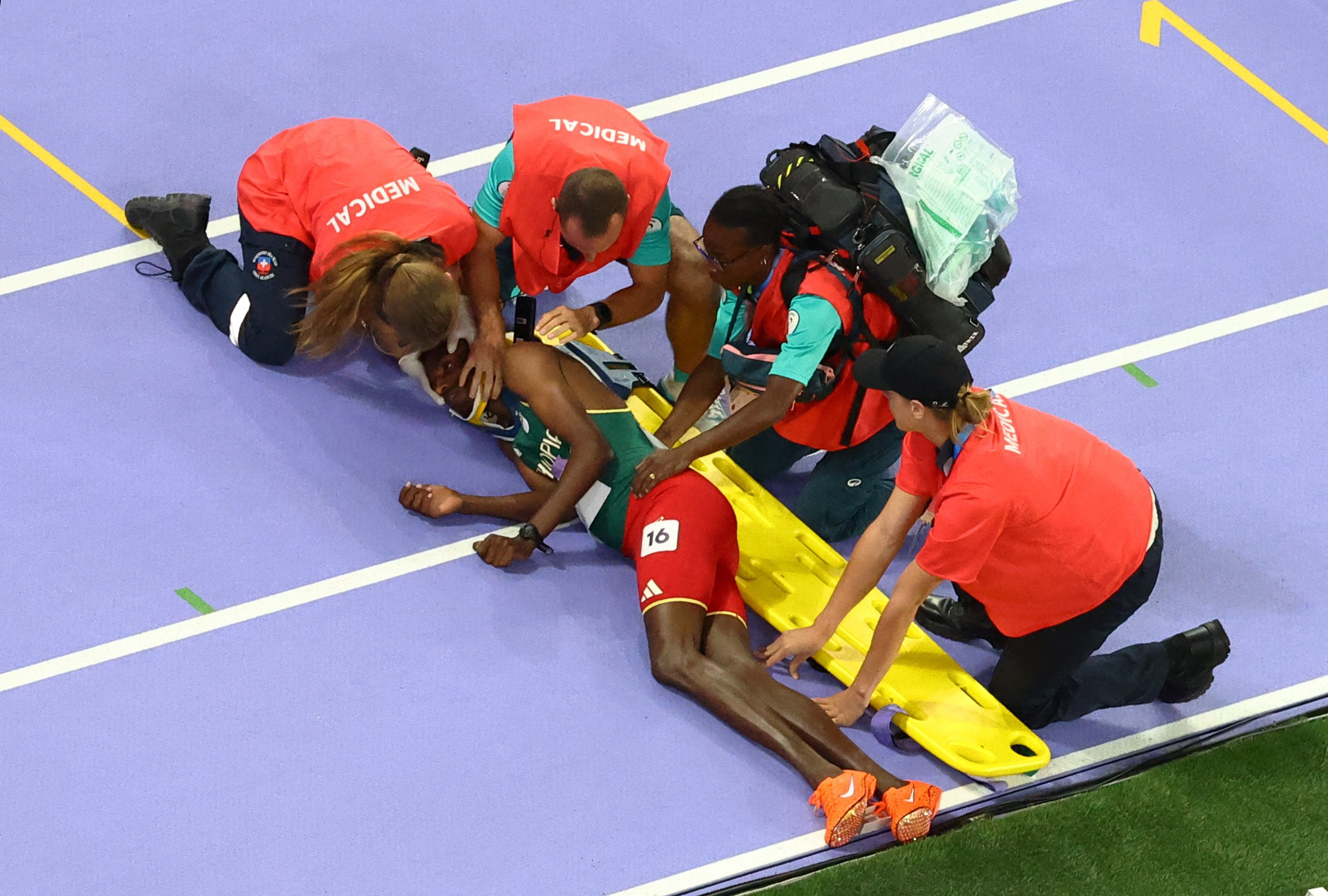 Paris 2024 Olympics - Athletics - Men's 3000m Steeplechase Final - Stade de France, Saint-Denis, France - August 07, 2024. Lamecha Girma of Ethiopia receives medical attention after sustaining an injury REUTERS