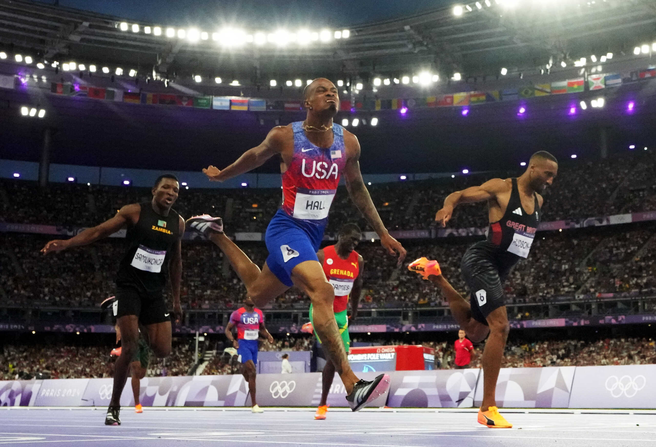 Paris 2024 Olympics - Athletics - Men's 400m Final - Stade de France, Saint-Denis, France - August 07, 2024. Quincy Hall of United States crosses the finish line to win the final alongside second placed Matthew Hudson-Smith of Britain and third palced Muzala Samukonga of Zambia REUTERS