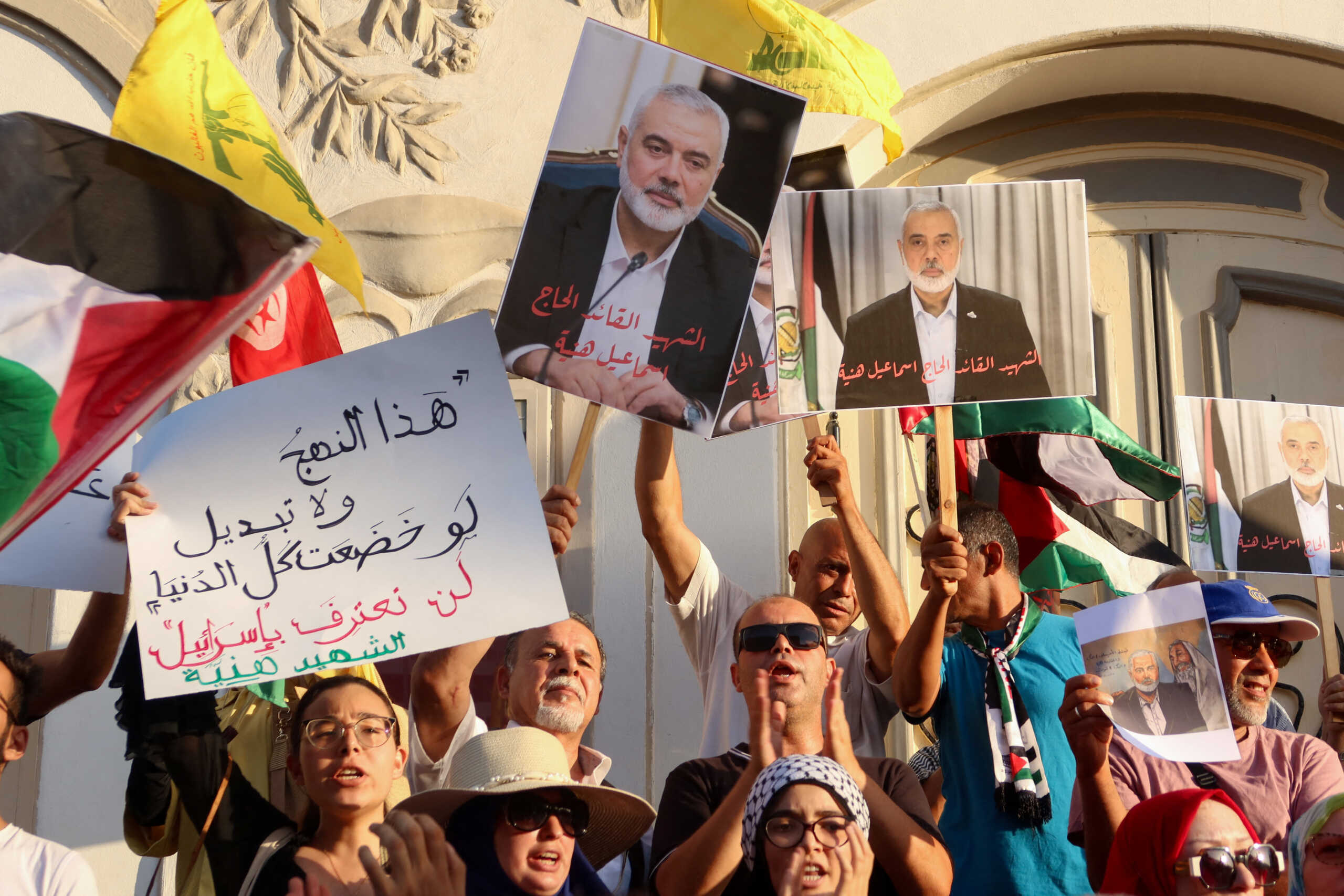 Demonstrators carry pictures of Hamas leader Ismail Haniyeh, who was killed in Iran, during a protest to condemn his killing, in Tunis, Tunisia July 31, 2024. REUTERS