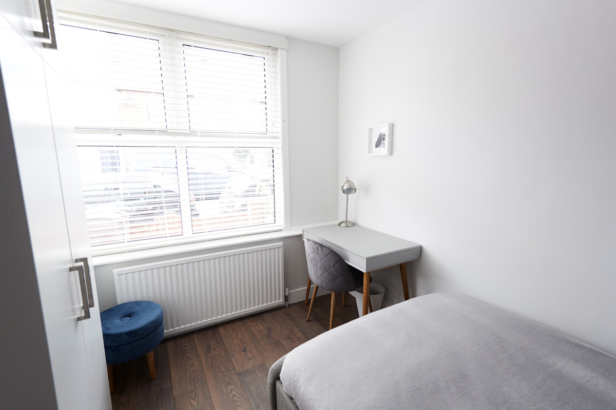 Modern bedroom with bed and desk by window