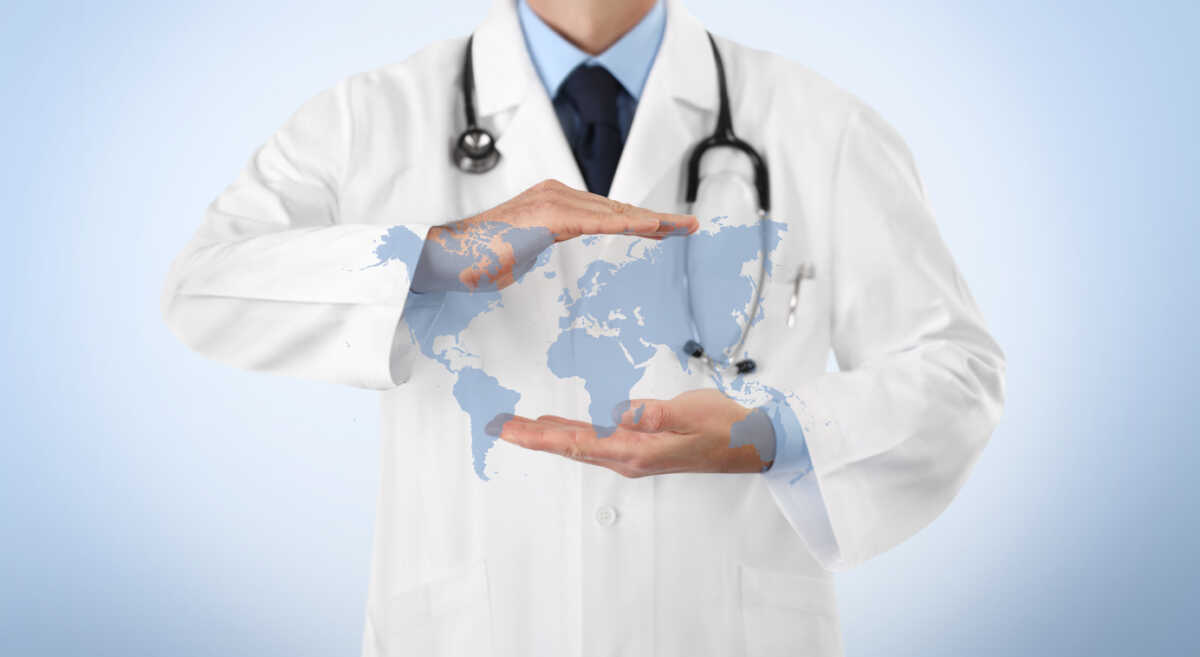 international medical coverage insurance concept, hands doctor covering world map symbol isolated on white background, copy space and web banner template