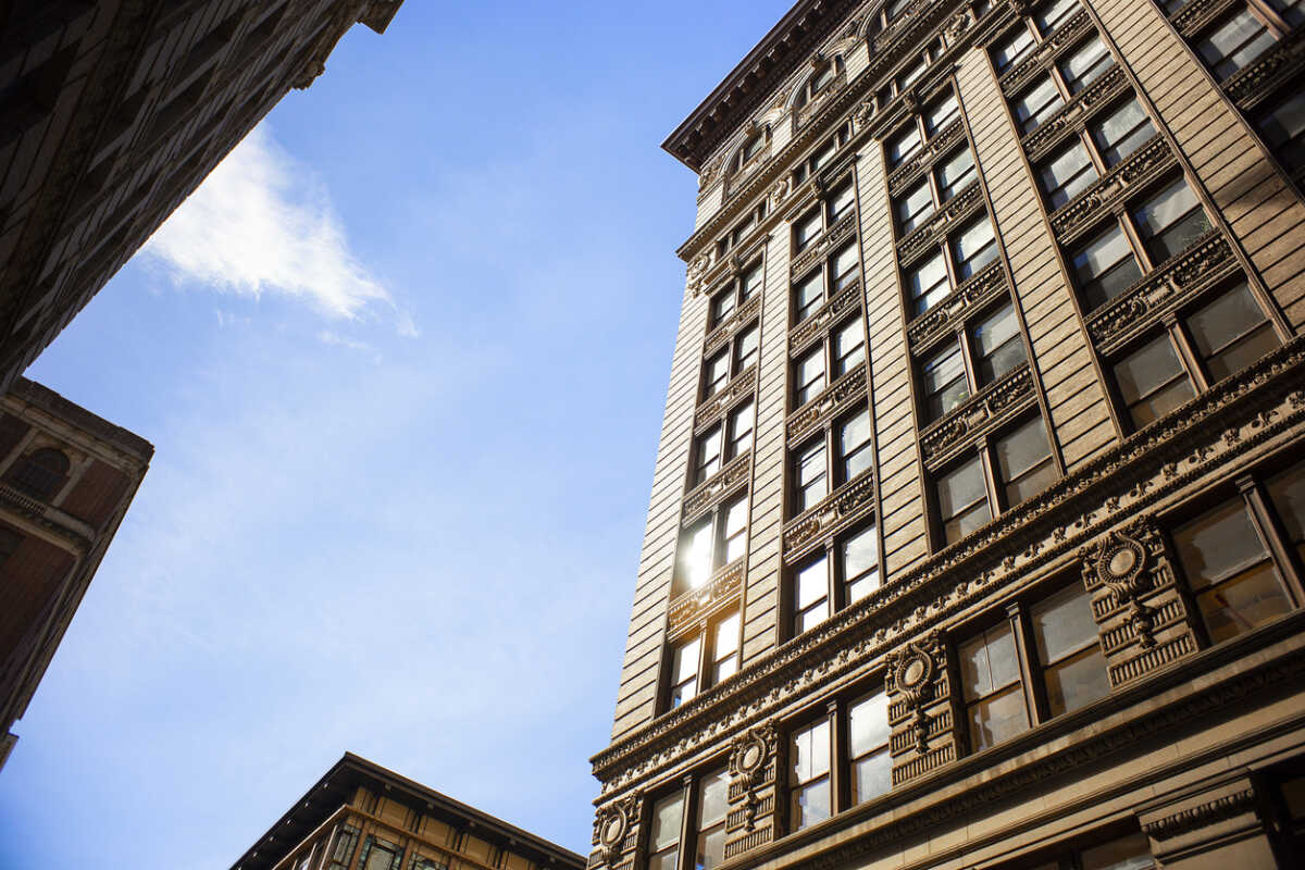 A pedestrian's perspective of buildings and sky in downtown New York City.