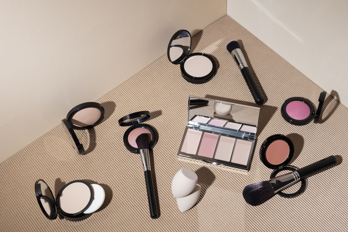decorative cosmetics for makeup, brushes and sponges for the face on a beige geometric background