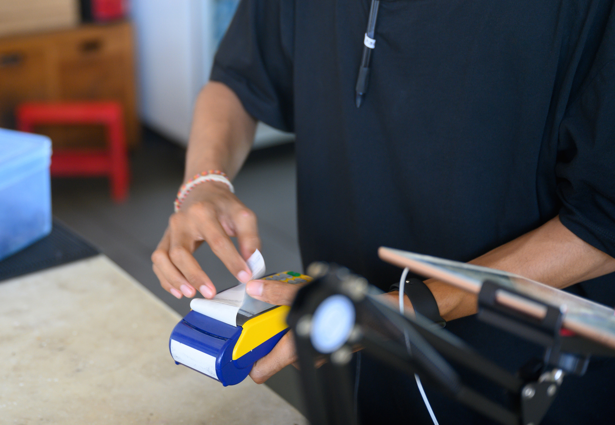 Close-up of unrecognizable sales clerk printing customer copy receipt on pos terminal, Nikon Z7