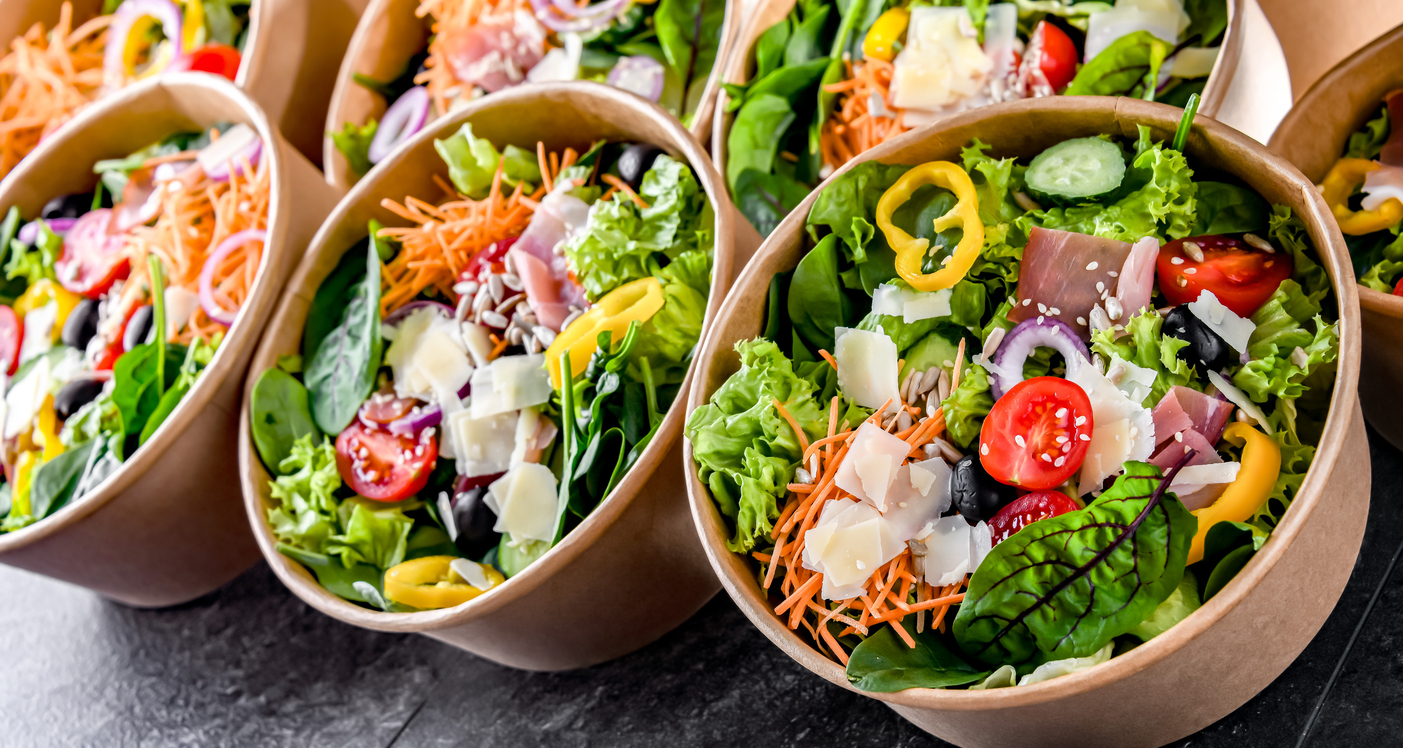 Round paper boxes with pre-packaged vegetable salads ready for sale