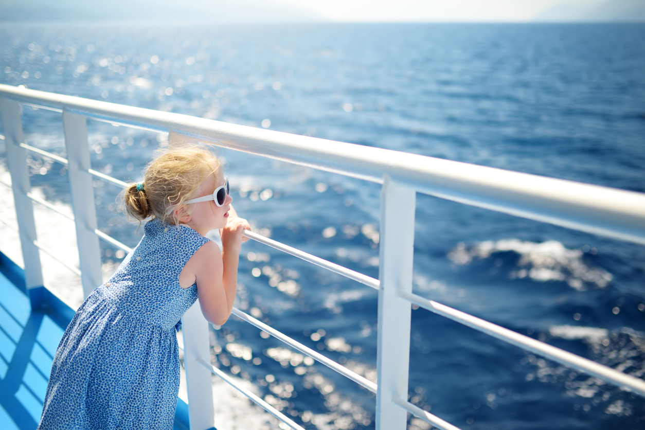 Adorable young girl enjoying ferry ride staring at the deep blue sea. Child having fun on summer family vacation in Greece. Kid sailing on a boat.