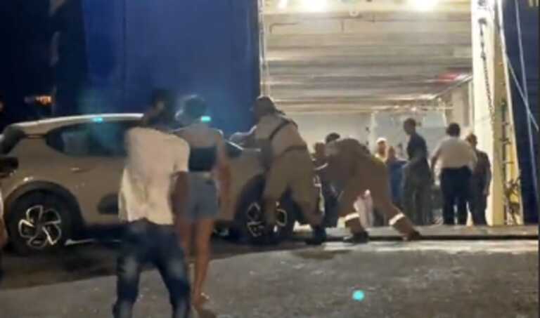 Passengers try to push their car onto the ferry after it was unable to dock at Andros due to bad weather