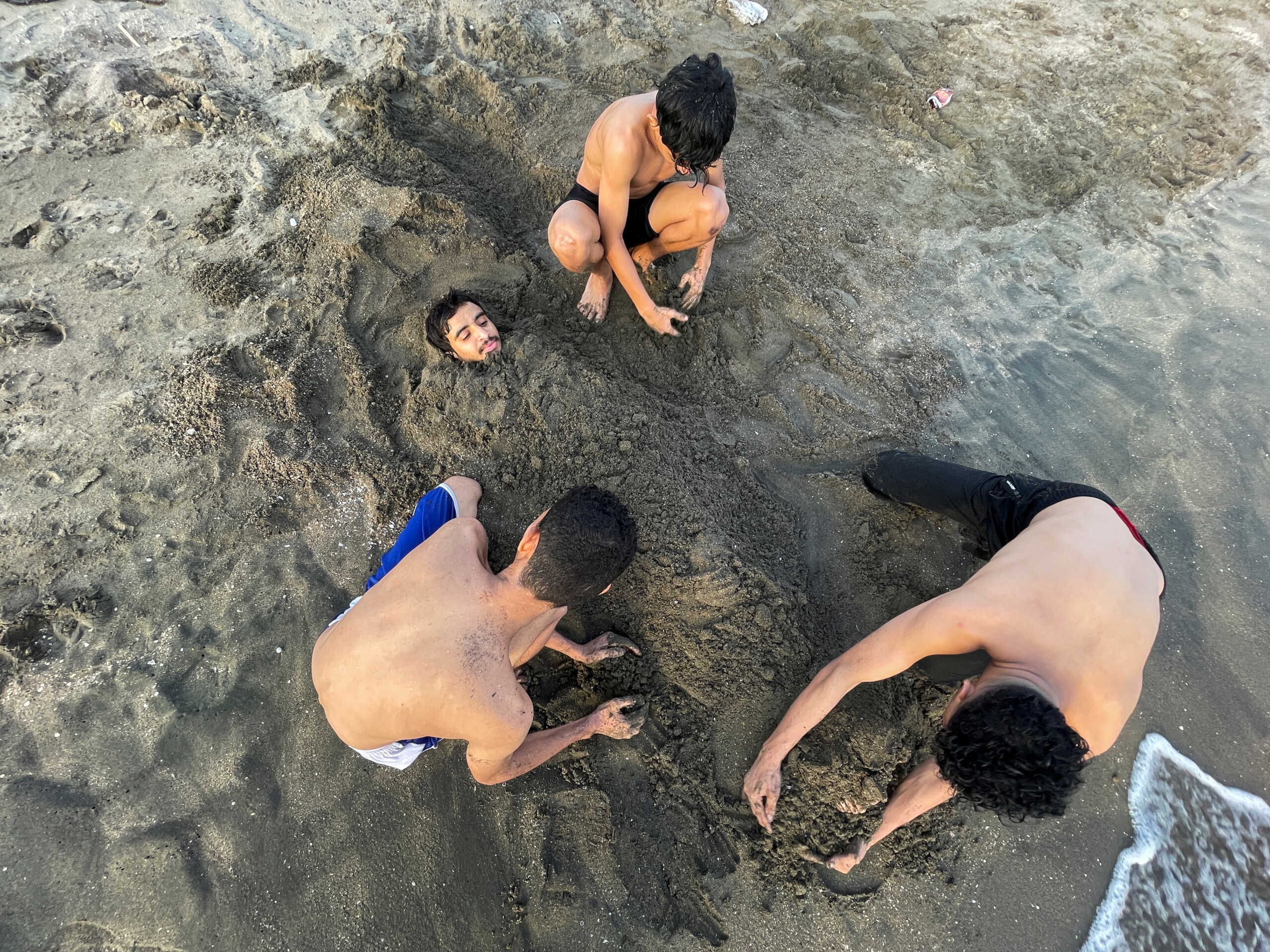 People play with sand on the beach at the Red Sea port city of Hodeidah, Yemen July 30, 2024. REUTERS