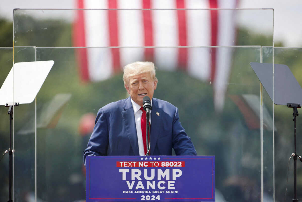 Republican presidential nominee and former U.S. President Donald Trump speaks from a bulletproof glass housing during a campaign rally, at the North Carolina Aviation Museum & Hall of Fame in Asheboro, North Carolina, U.S. August 21, 2024. REUTERS
