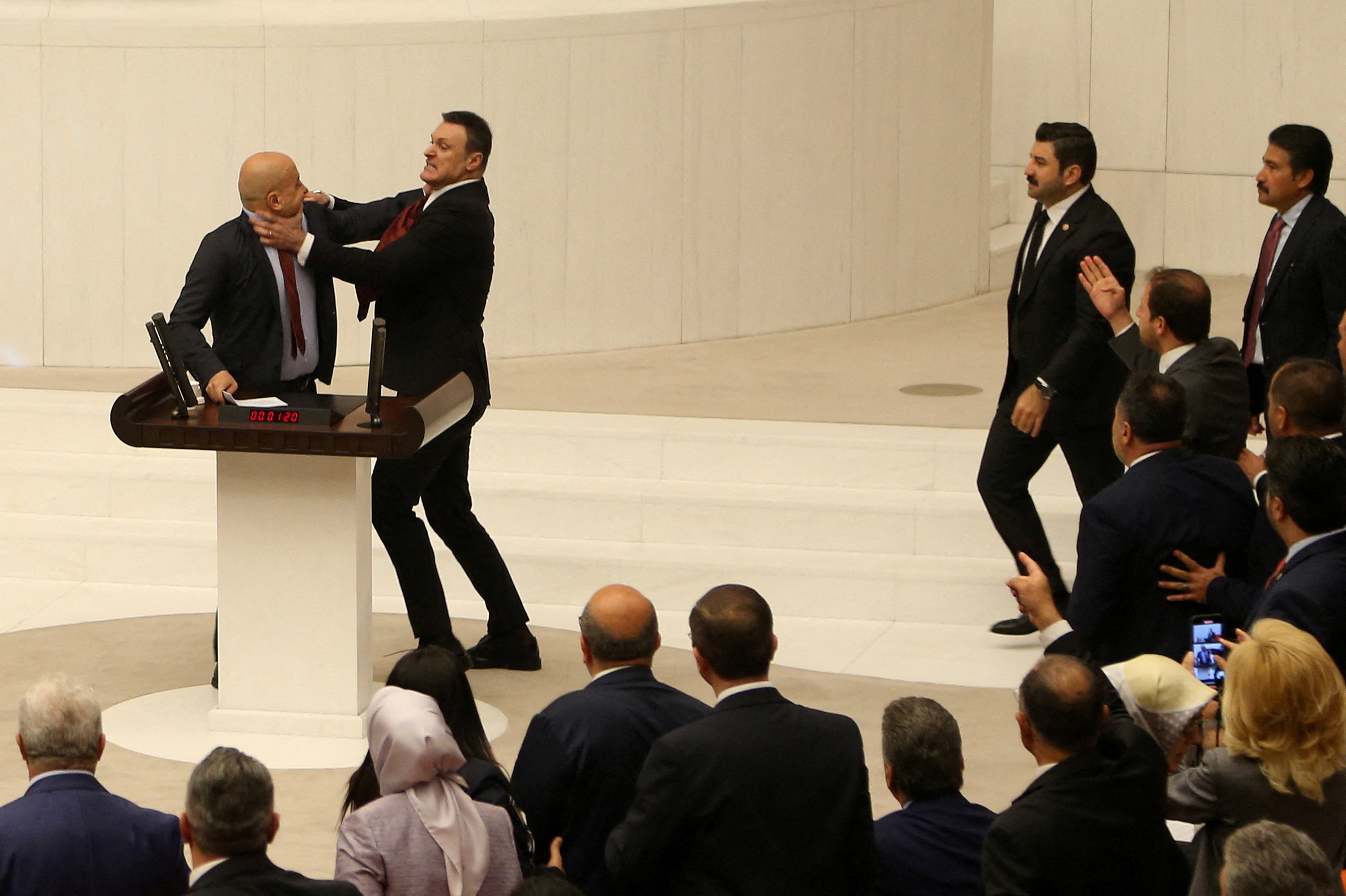 Turkey's AK Party lawmaker Alpay Ozalan scuffles with Workers' Party of Turkey (TIP) lawmaker Ahmet Sik, who was speaking during an extraordinary meeting of the Turkish parliament to discuss jailed opposition lawmaker Can Atalay's return to the assembly, in Ankara, Turkey August 16, 2024. REUTERS