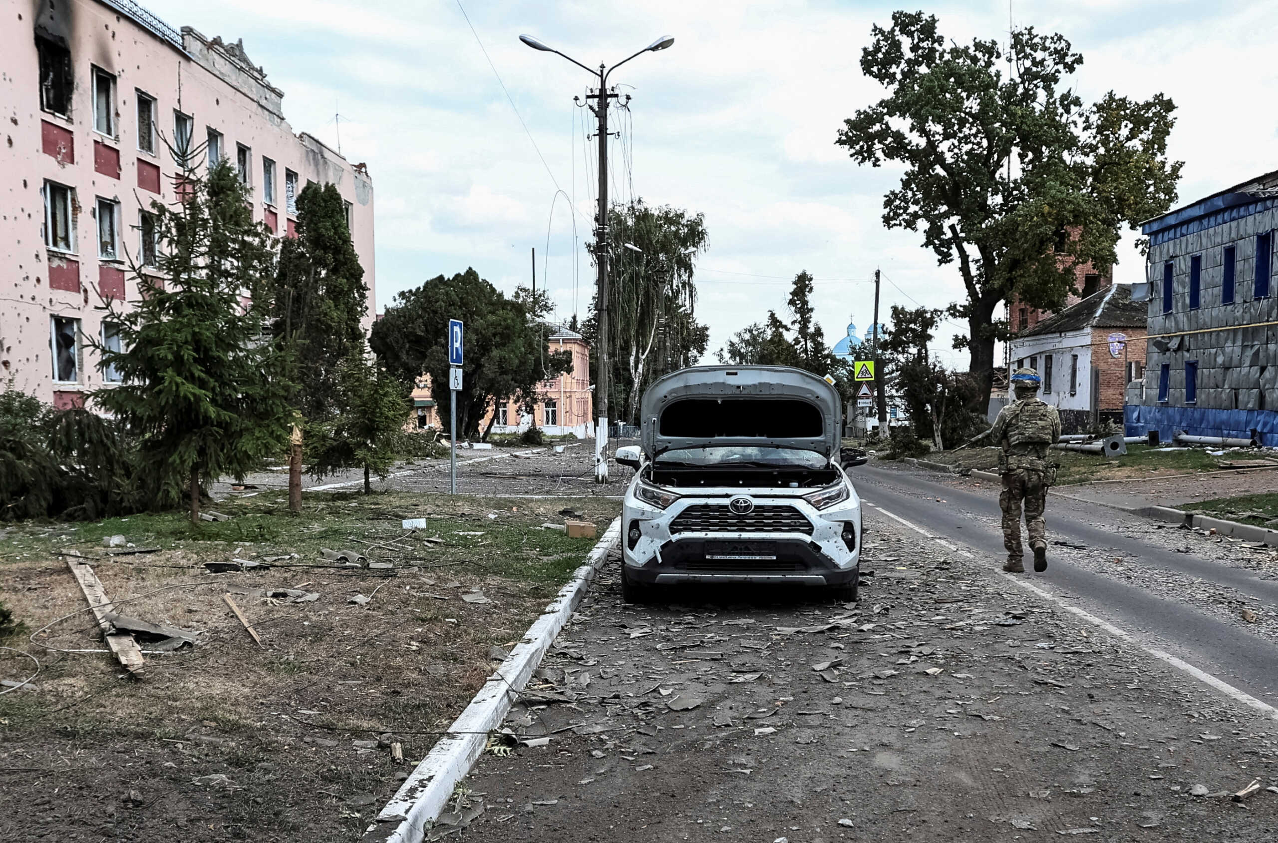 A Ukrainian serviceman patrols a street next to buildings, damaged during recent fighting between Ukrainian and Russian forces in controlled by Ukrainian army the town of Sudzha, Kursk region, Russia August 16, 2024. REUTERS