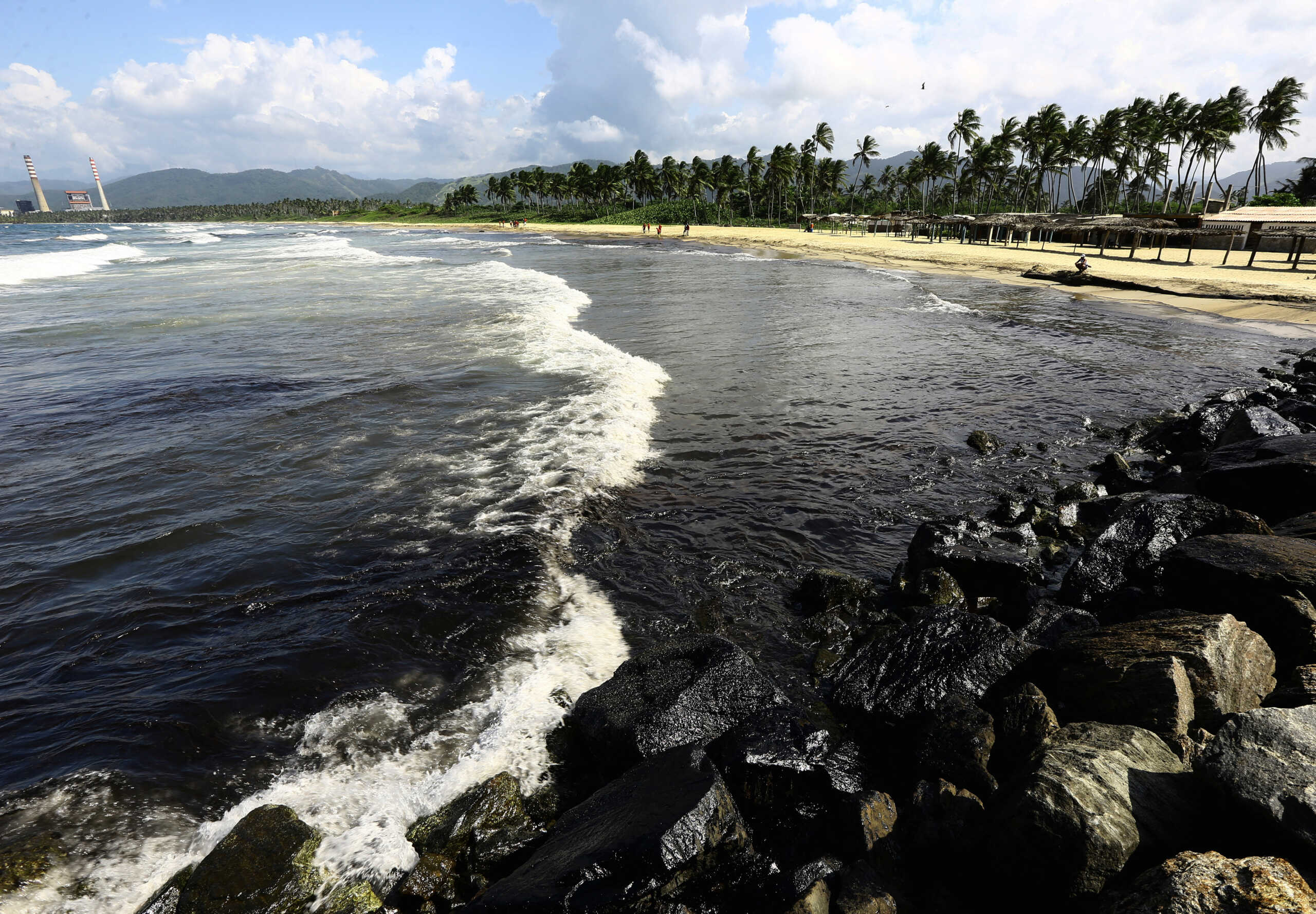 Oil slick is seen in the ocean and covering the rocks on a beach near the Venezuelan state oil company PDVSA's El Palito refinery, in Boca de Aroa, Venezuela August 16, 2024. REUTERS