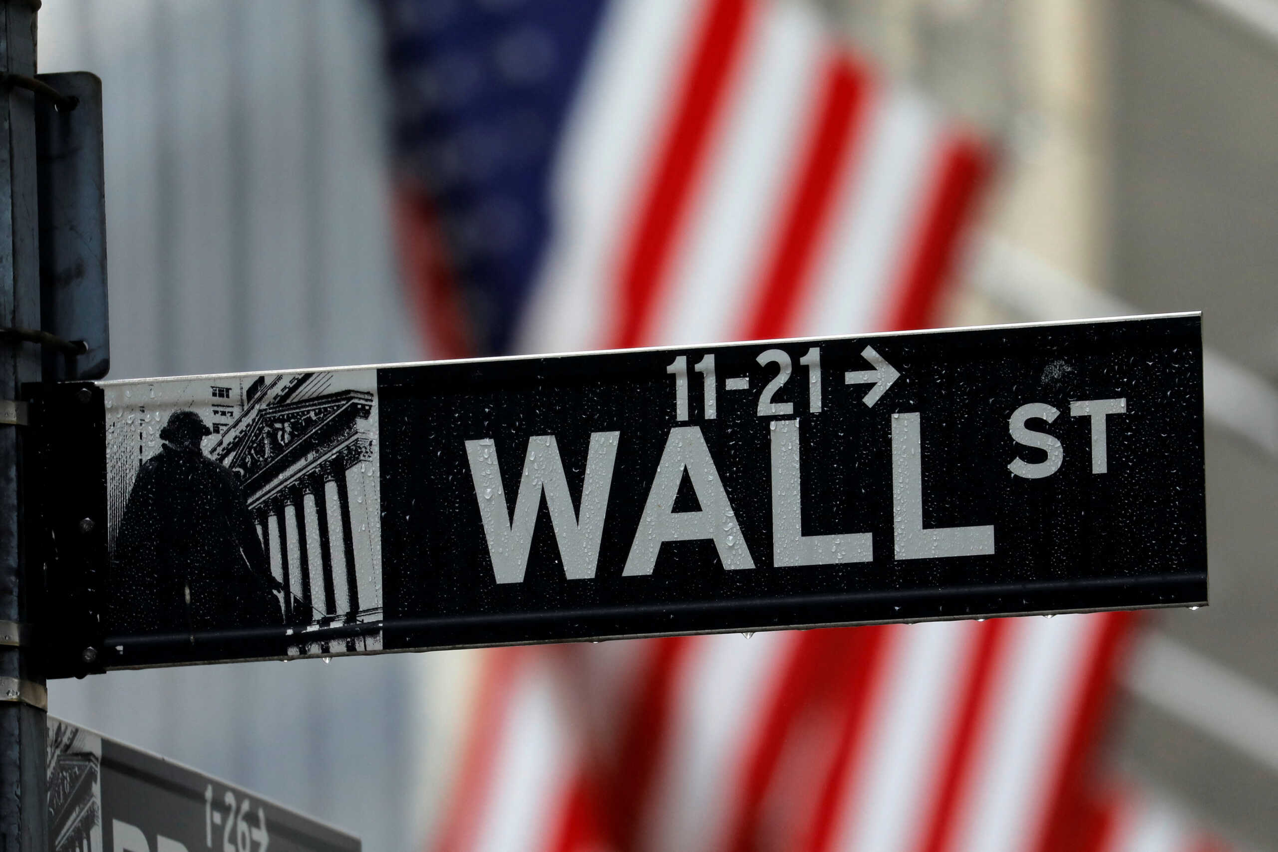 FILE PHOTO: A sign for Wall Street outside the New York Stock Exchange in Manhattan in New York City, New York, U.S., October 26, 2020. REUTERS
