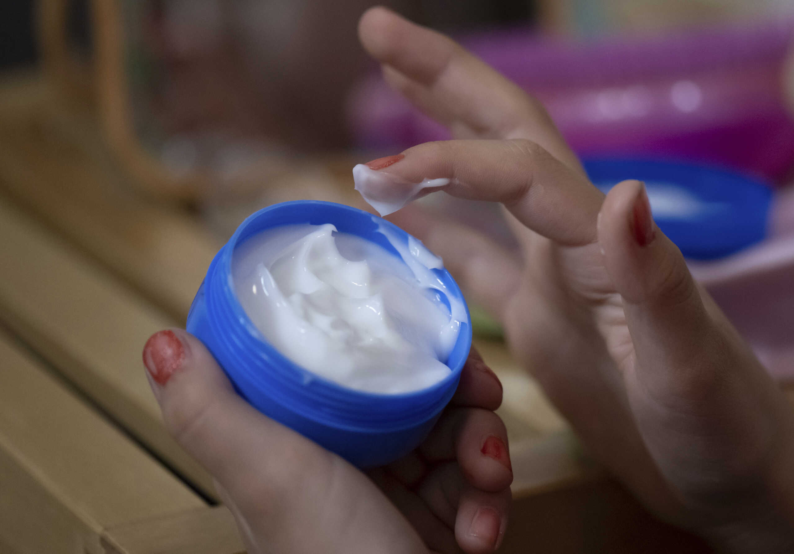 PRODUCTION - 18 September 2024, Saxony, Leipzig: ILLUSTRATION - A girl takes face cream from a tin. Cosmetic trends among children are playing an increasingly important role. Embellished faces are constantly present on social media. Even children get the feeling that they have to do something for their skin - with consequences. Photo by: Hendrik Schmidt