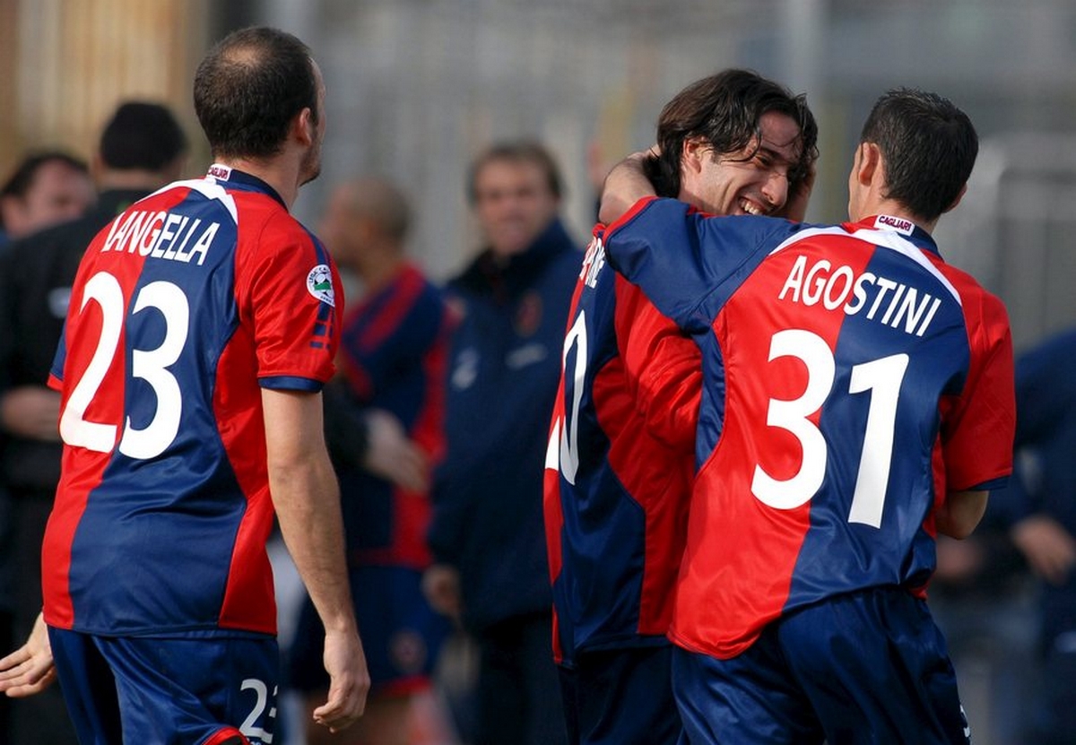 epa00929359 Forward Andrea Capone (C) pf Cagliari is congratulated by teammates Alessandro Agostini (R) and Antonio Langella after scoring against AC Siena during the Italian Serie A soccer match Cagliari vs AC Siena, which ended with a 2-2 draw on Sunday 11 February 2007. Italy's first division Serie A resumed on Sunday with spectators allowed into just five of the 10 matches. Milan's San Siro-Giuseppe Meazza stadium was open only to AC Milan's 37,000 season ticket holders. The rest took place behind closed doors - the result of a tough anti-hooligan plan approved by the government in response to the death of policeman Filippo Raciti during rioting at a Serie A match last week.  EPA