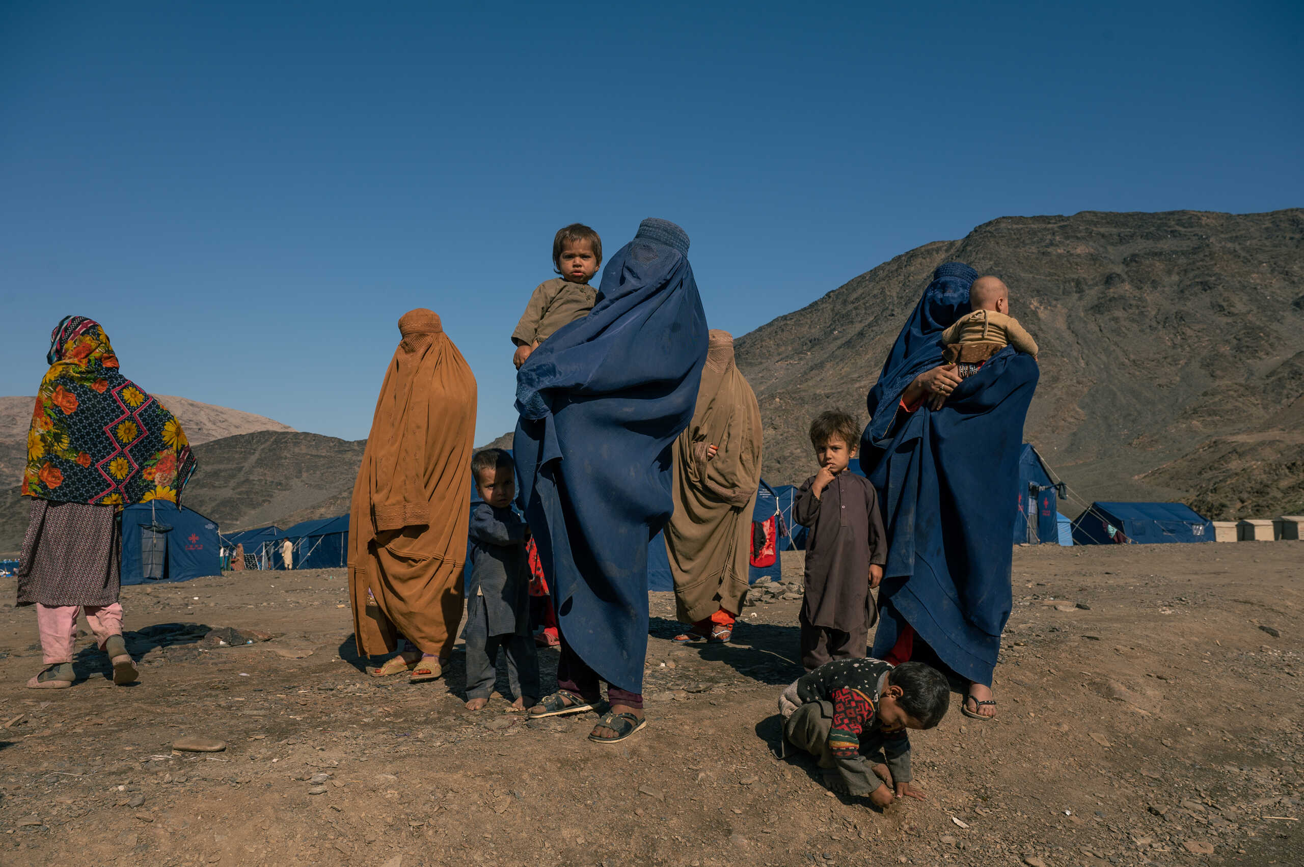 TORKHAM - NOVEMBER 10: Returnees women and their children stand in a humanitarian camp set near the Torkham border crossing in Eastern Afghanistan, for returnees who have been deported or coerced into leaving Pakistan, on November 10, 2023. Out of 1.4 millions Afghans living illegally in Pakistan, 250,000 people have so far returned as part of Islamabad's massive deportation and repatriation campaignan effort that has led the Taliban to start managing a major humanitarian crisis, with camps, food distributions, bus services and more. (Photo by Elise Blanchard for The Washington Post via Getty Images)