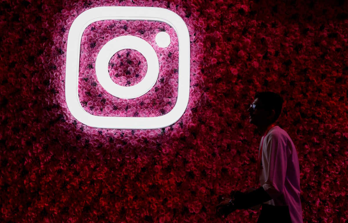 FILE PHOTO: A man walks past a logo of mobile application Instagram, during a conference in Mumbai, India, September 20, 2023. REUTERS