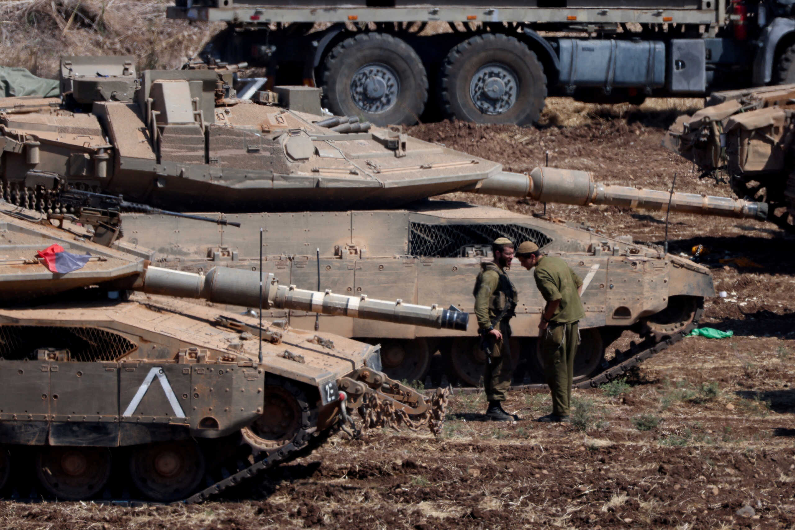 Israeli members of the military stand next to armoured vehicles, amid cross-border hostilities between Hezbollah and Israel, in northern Israel, September 30, 2024. REUTERS