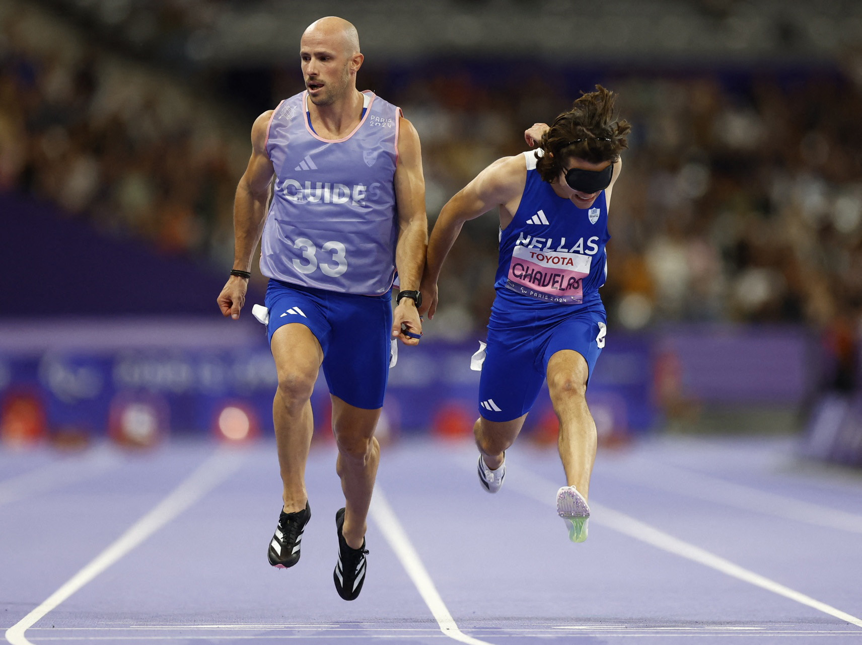 Paris 2024 Paralympics - Athletics - Men's 100m - T11 Semifinals - Stade de France, Saint-Denis, France - September 4, 2024 Athanasios Ghavelas of Greece with guide Ioannis Nyfantopoulos crosses the line to win semifinal 1 REUTERS