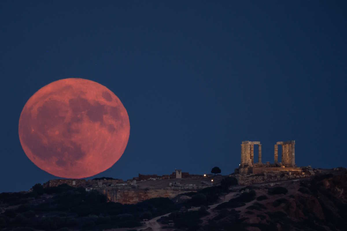 A supermoon, known as the blue moon and "Sturgeon Moon", rises next to the Temple of Poseidon, on Cape Sounion, near Athens, Greece, August 19, 2024. REUTERS