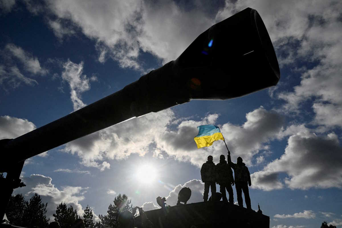 FILE PHOTO: Ukrainian personnel hold a Ukrainian flag as they stand on a Challenger 2 tank during training at Bovington Camp, near Wool in southwestern Britain, February 22, 2023. REUTERS