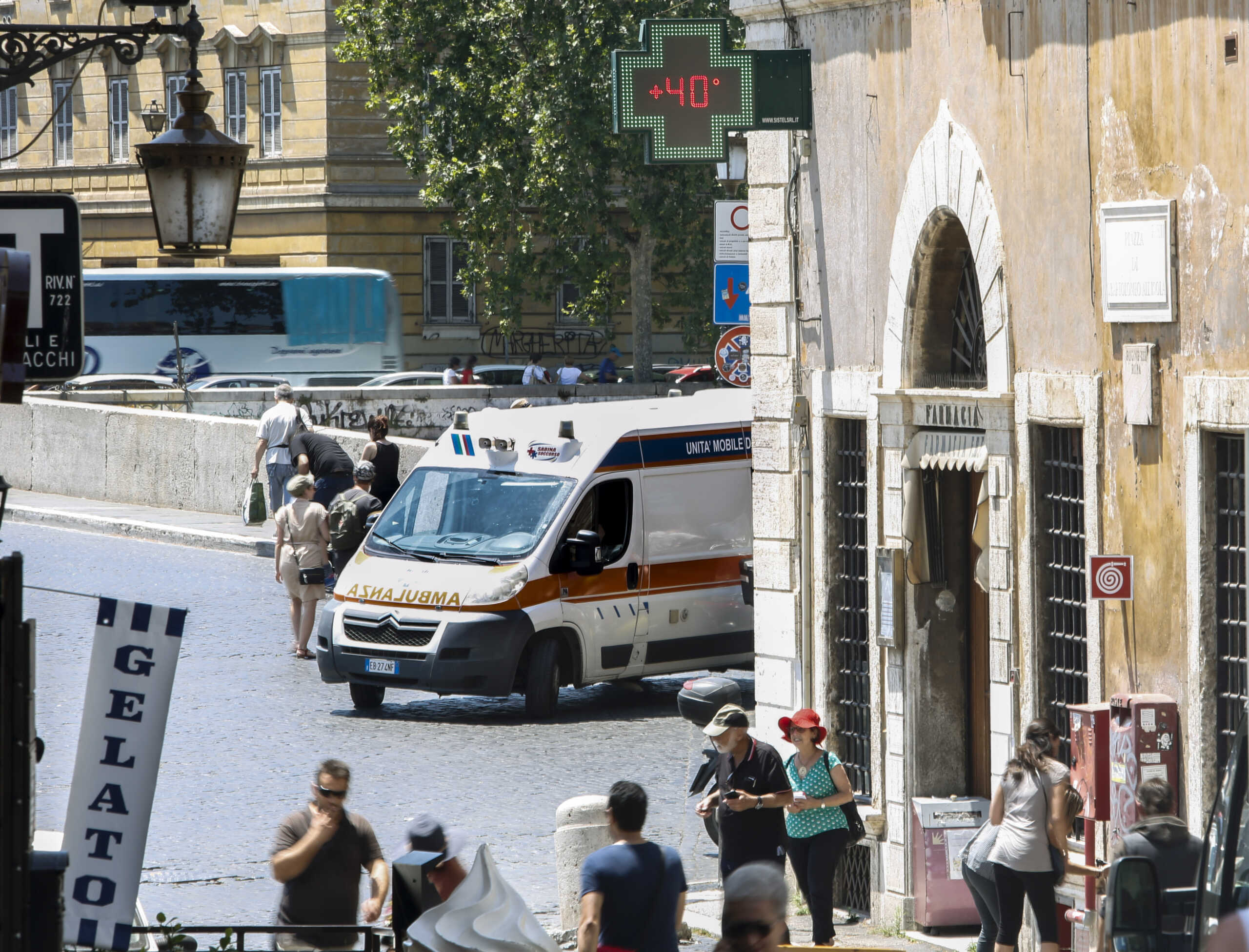 An ambulance waits near the thermometer of a pharmacy shop in Rome displaying 40 Celsius degree (104F), Friday, June 28, 2019. Torrid weather gripped large parts of western and central Europe, setting new June temperature records. (AP Photo