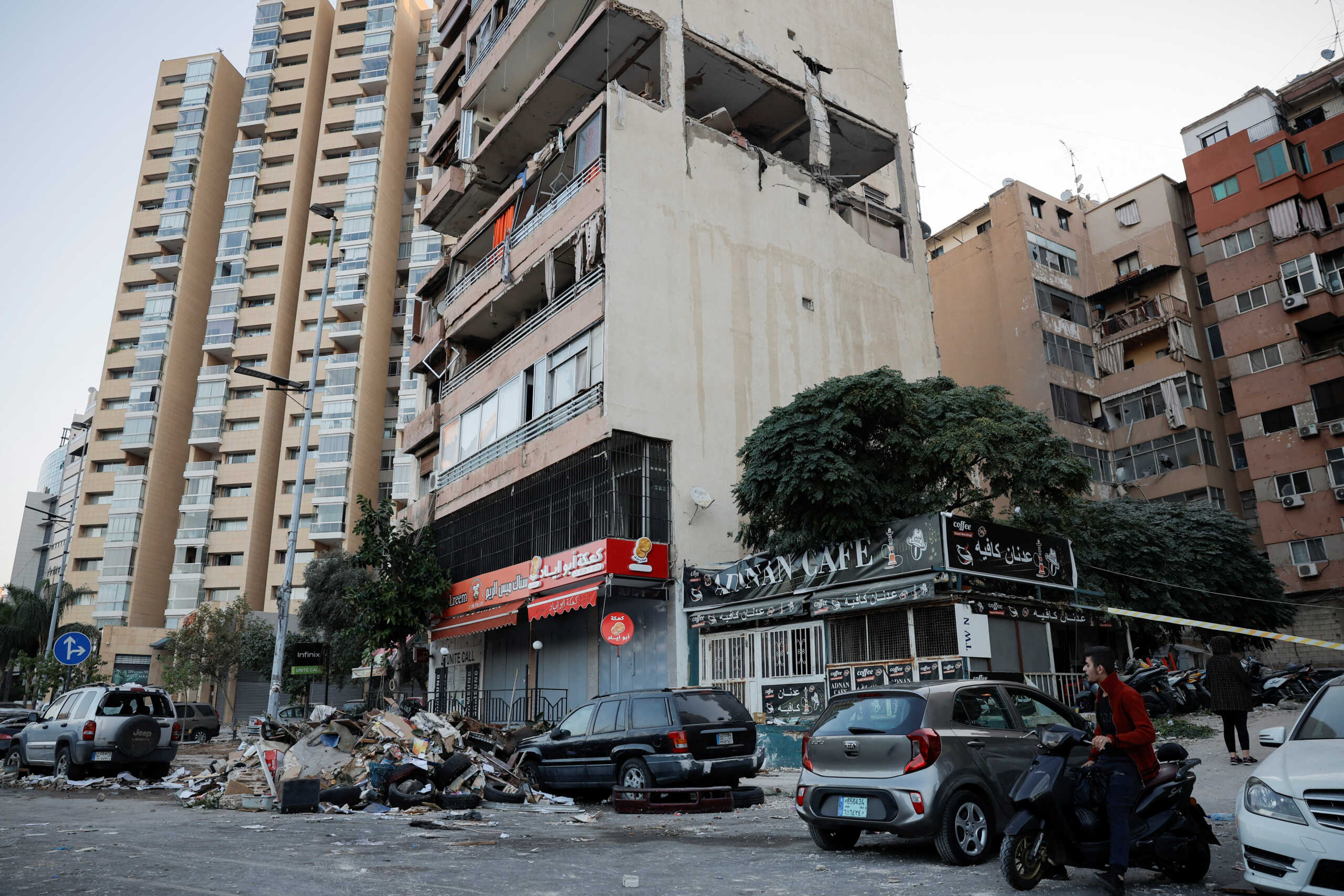 People pass by buildings damaged in an Israeli strike, amid ongoing cross-border hostilities between Hezbollah and Israeli forces, in Kola, central Beirut, Lebanon September 30, 2024. REUTERS
