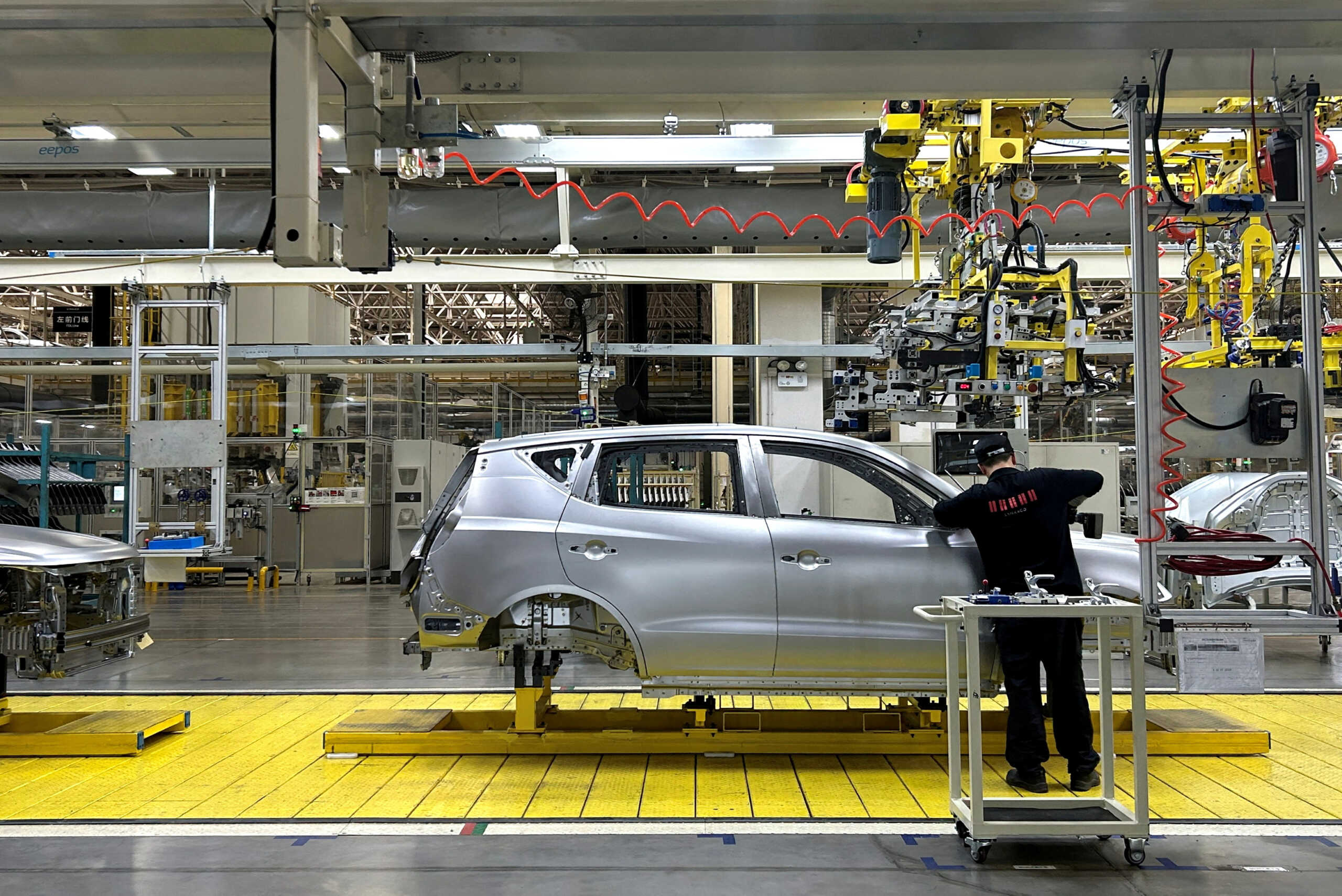 FILE PHOTO: A staff member works on an assembly line manufacturing Geely's GX6 cars, at the Geely's plant in Chengdu, Sichuan province, China April 13, 2023. REUTERS