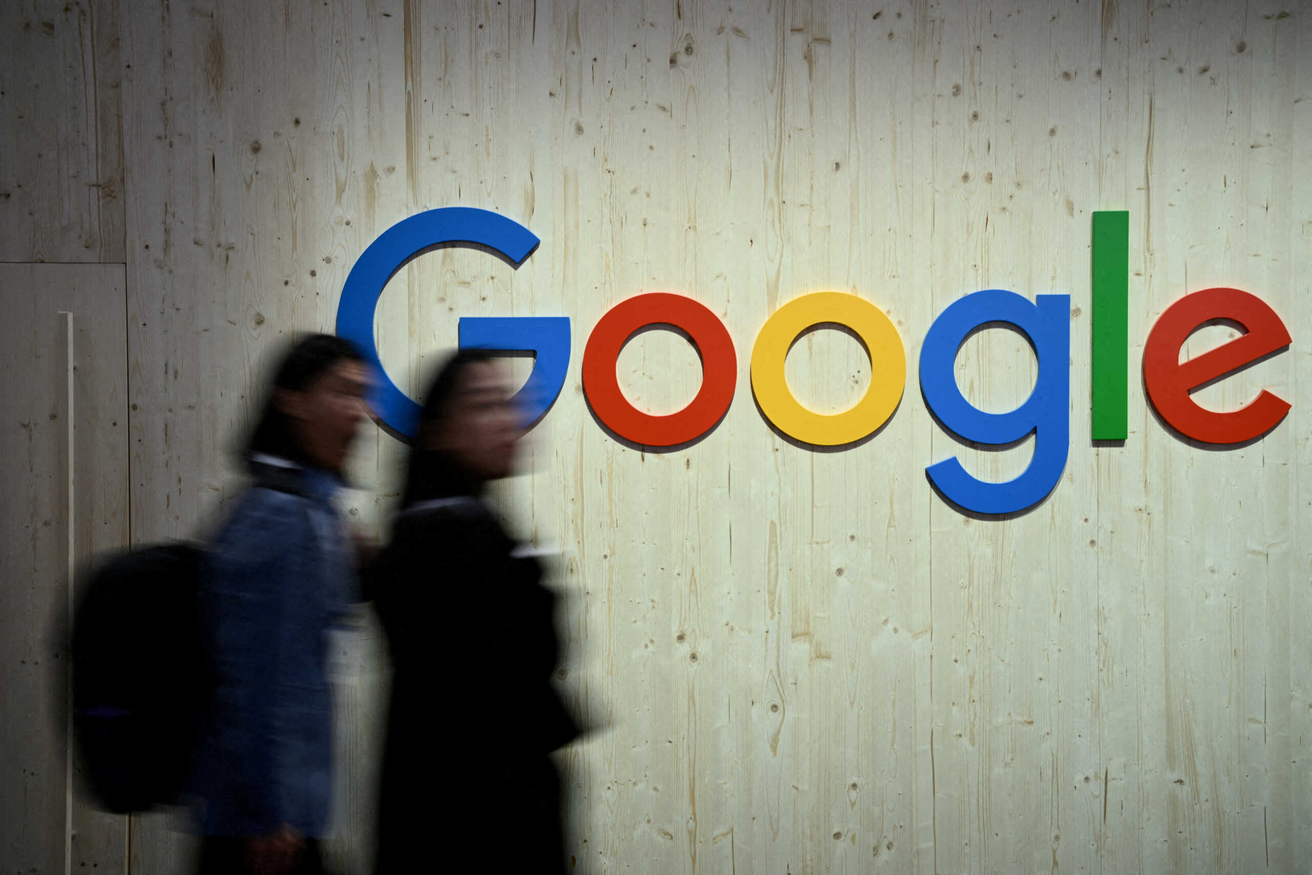FILE PHOTO: FILE PHOTO: People walk next to a Google logo during a trade fair in Hannover Messe, in Hanover, Germany, April 22, 2024.  REUTERS