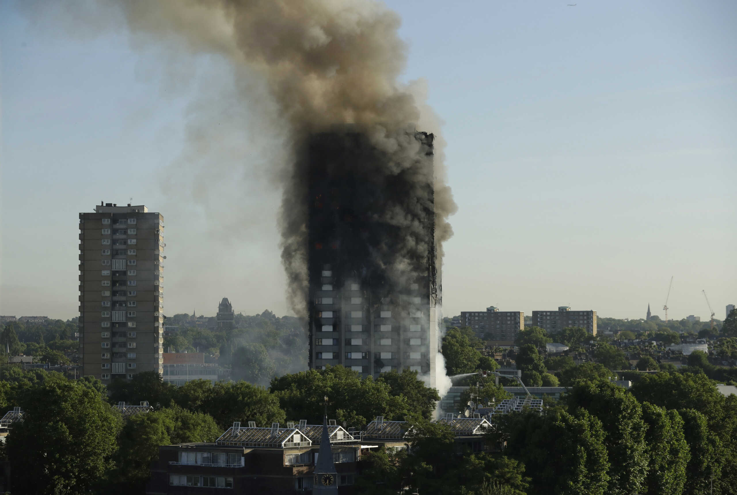 FILE - In this file photo dated Wednesday, June 14, 2017, smoke rises from a fire in the Grenfell Tower building in west London. A report is due to be released Wednesday Oct. 30, 2019, following a far reaching inquiry into the deadly apartment block fire. (AP Photo