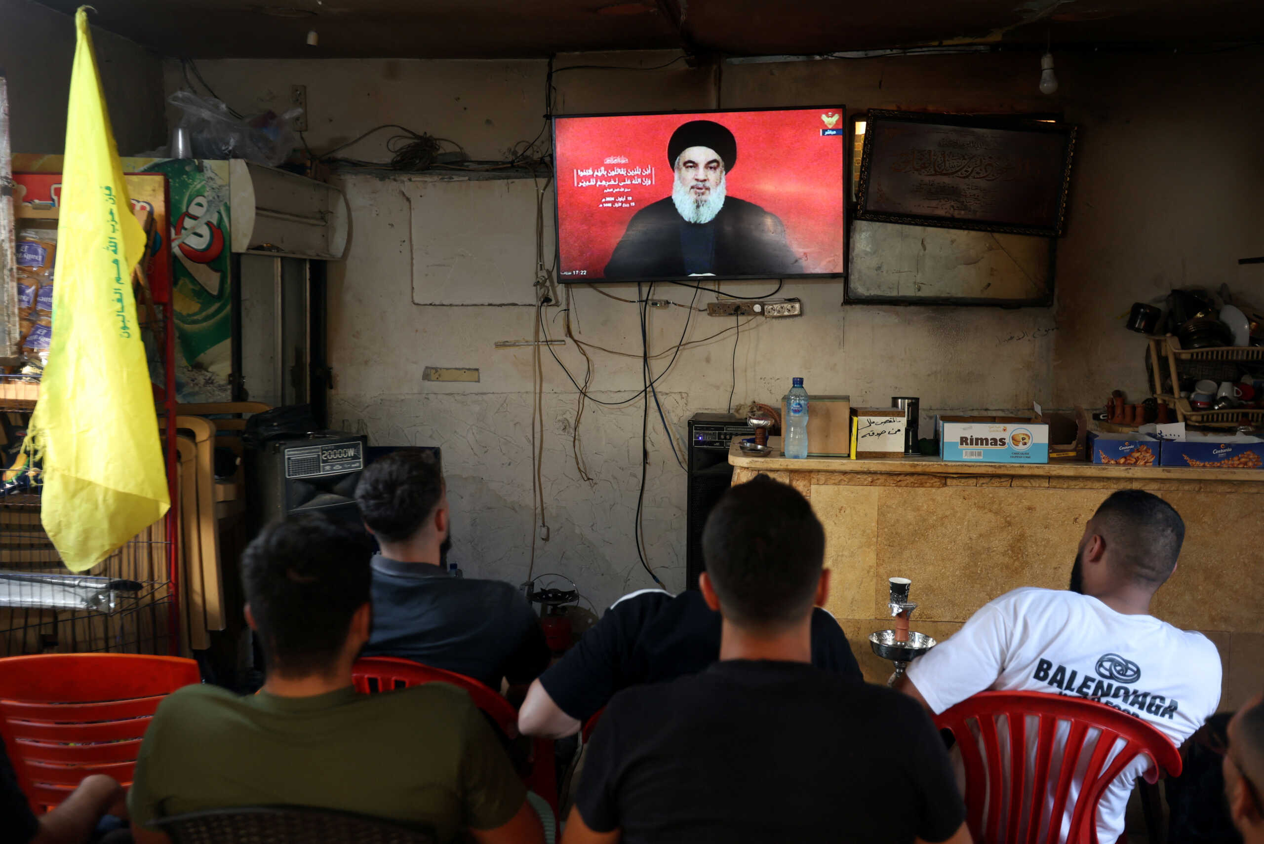 People watch Lebanon's Hezbollah leader Sayyed Hassan Nasrallah delivering a televised address, as they sit at a cafe in Sidon, Lebanon September 19, 2024. REUTERS