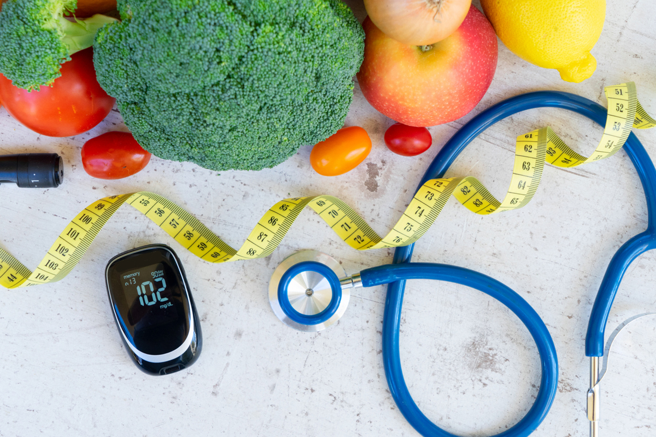 raw vegetables with blood glucose meter, lancet, measuring tape and stethoscope, diabetes healthy diet concept