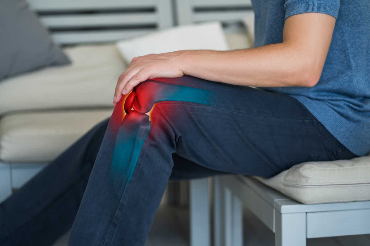 Knee pain, man suffering from osteoarthritis at home, chiropractic treatments concept