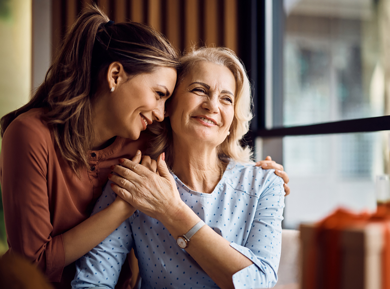 Happy senior woman enjoying in daughter's affection on Mother's day.