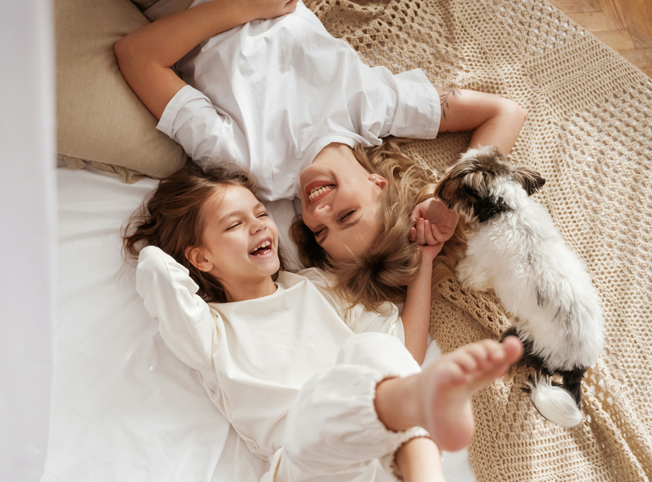 Cute dog is with them. Mother with daughter are at home together.