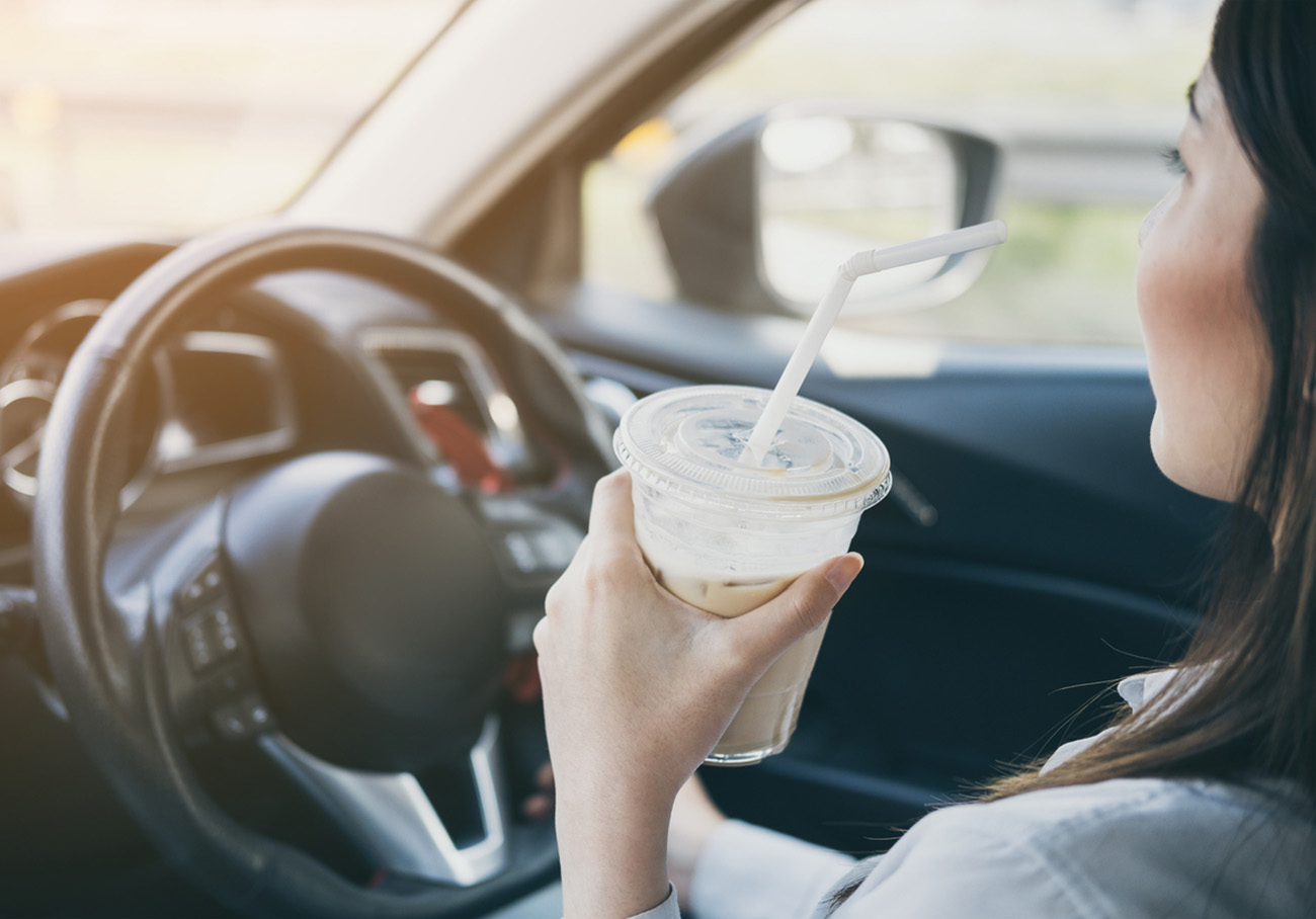 Woman Drinking Coffee While Driving Car